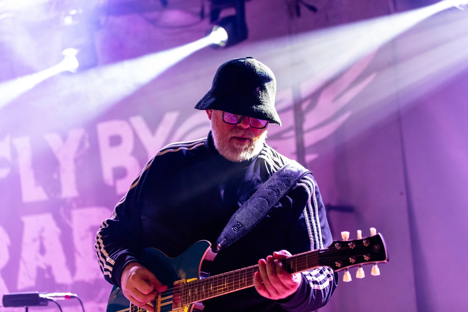 Fly By Radio guitarist performing with FBR banner