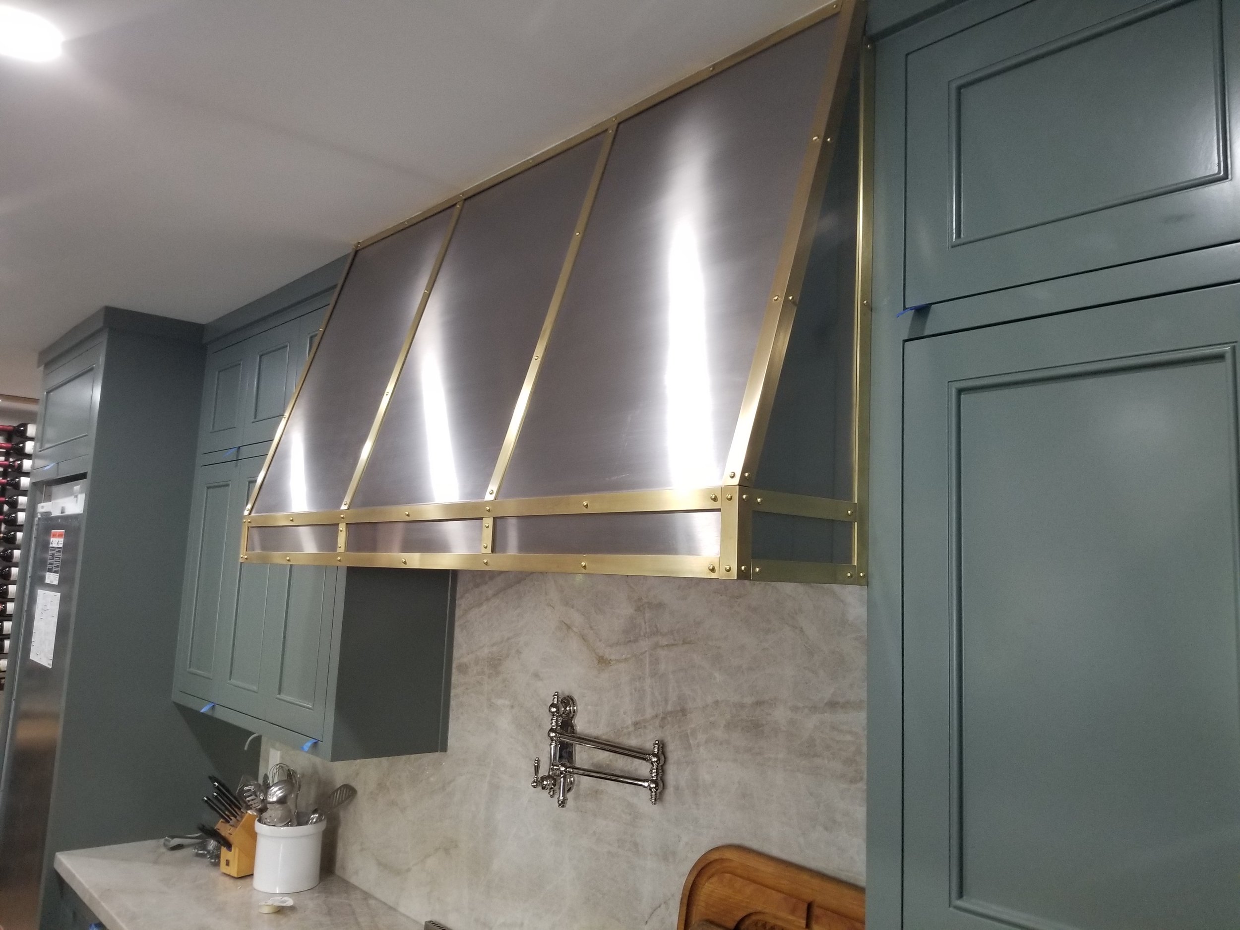STAINLESS STEEL RANGE HOOD WITH BRASS STRAPS AND RIVETS