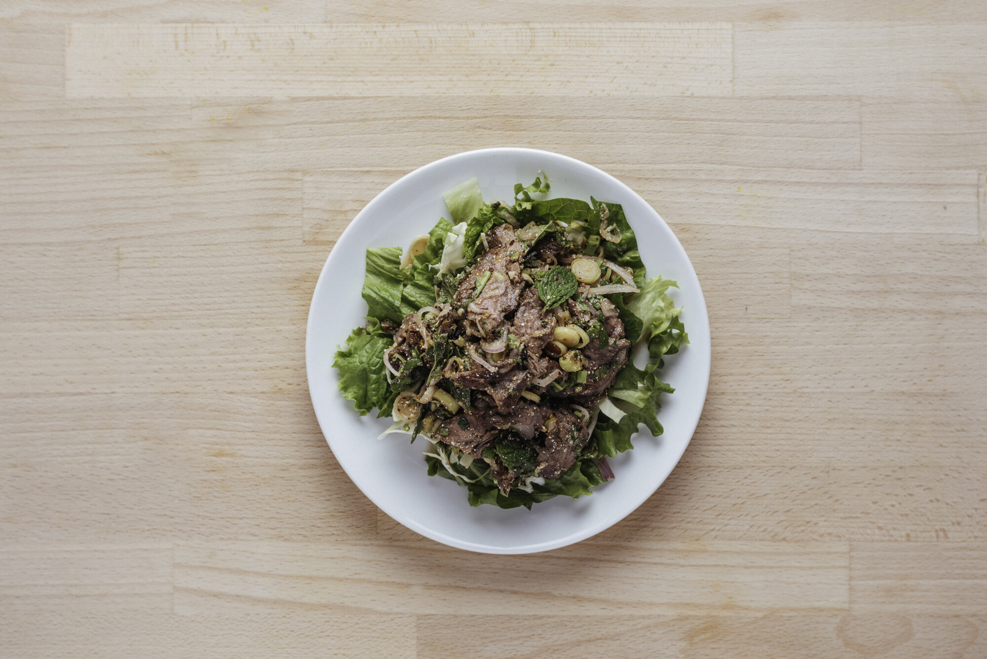   NORTHEASTERN STYLE STEAK - 19   thinly sliced skirt steak tossed with shallots, mint leaves, cilantro, lemongrass, green lettuce, toasted ground rice, soy sauce, dry chili, lime juice, fish sauce 