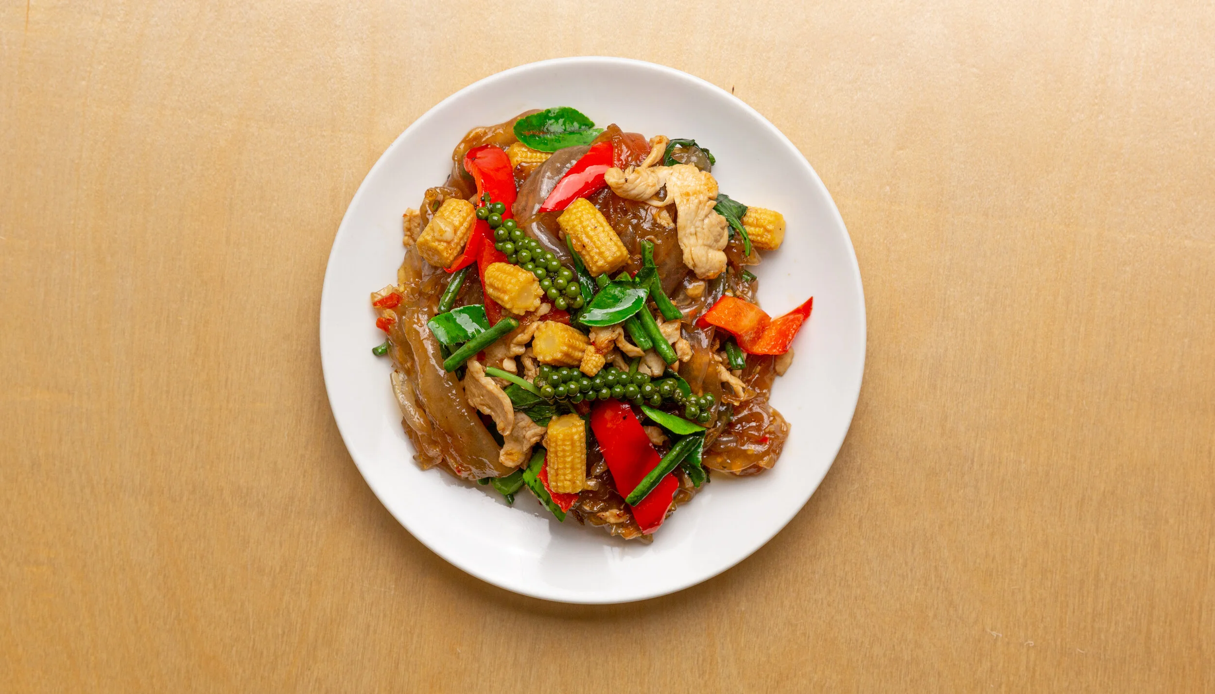   DRUNKEN NOODLES - 17     choice of prawns (+2), chicken breast, minced pork or tofu  : fresh flat sheet noodles, baby corn, bell pepper, fresh peppercorn, lime leaf, garlic, thai basil, soy sauce, fish sauce, oyster sauce 