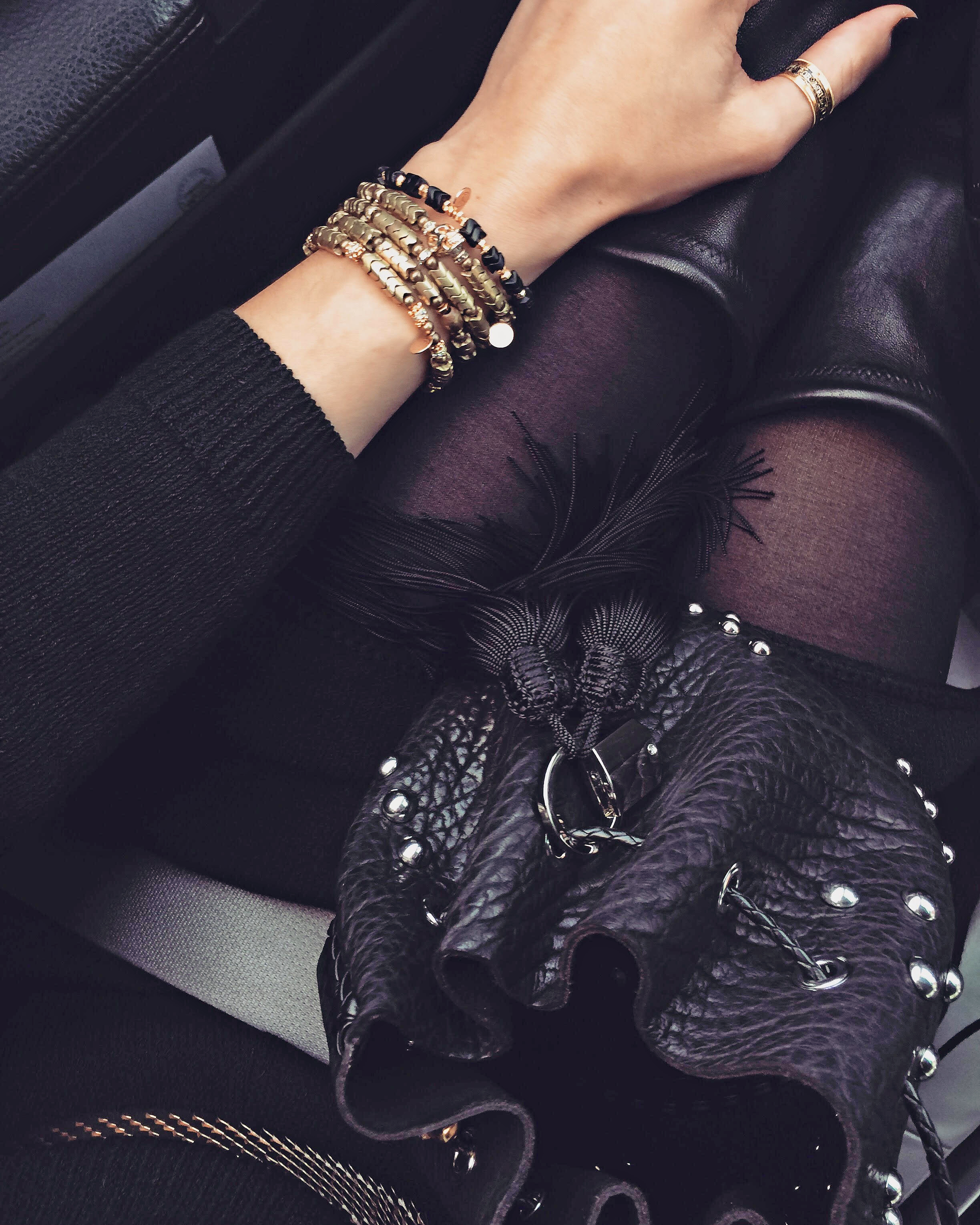 Up-close with the mini bucket's stud detail, removable key ring, and long silk tassels.