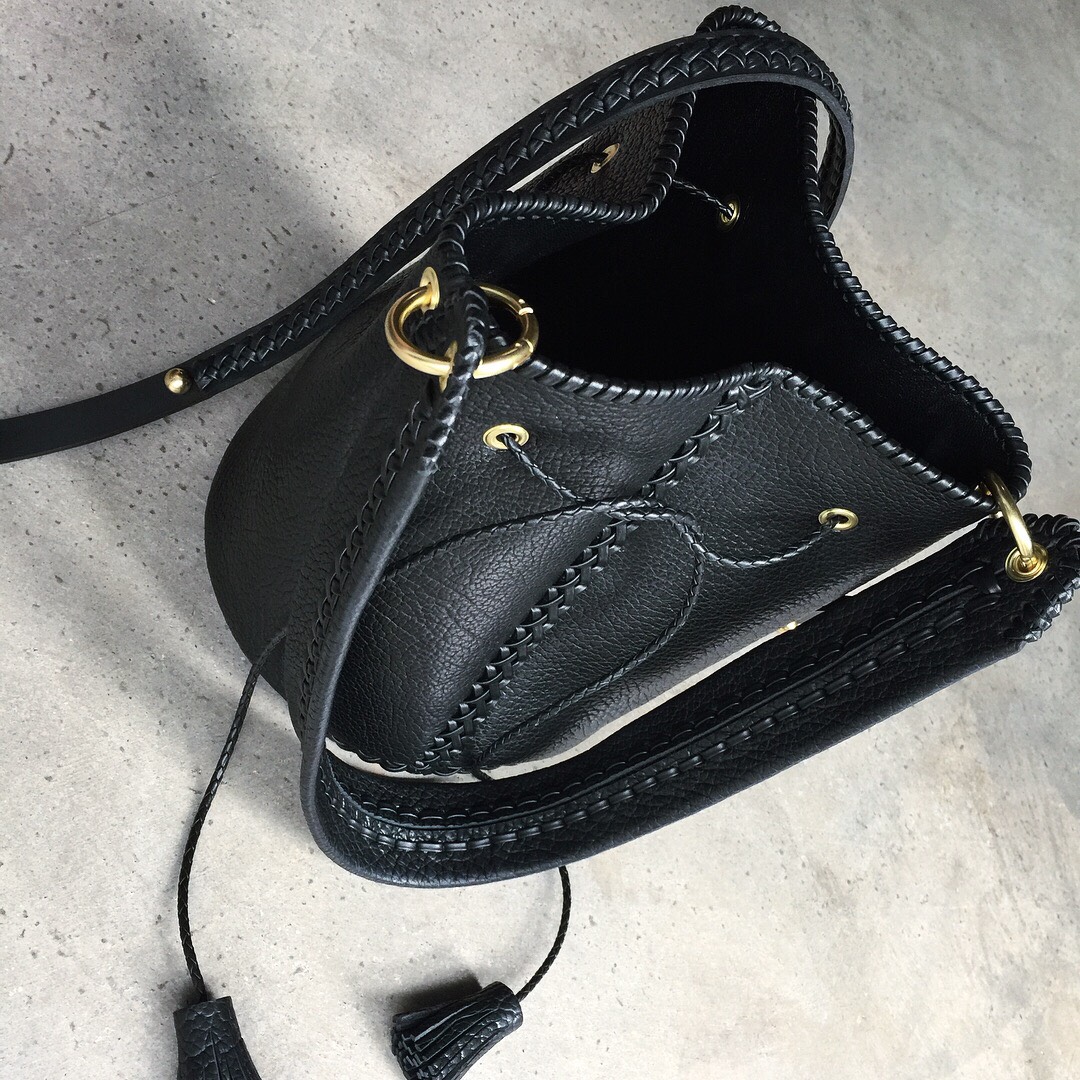 Braided oversized bucket back lined in black lamb with gold hardware and two detachable braided leather straps