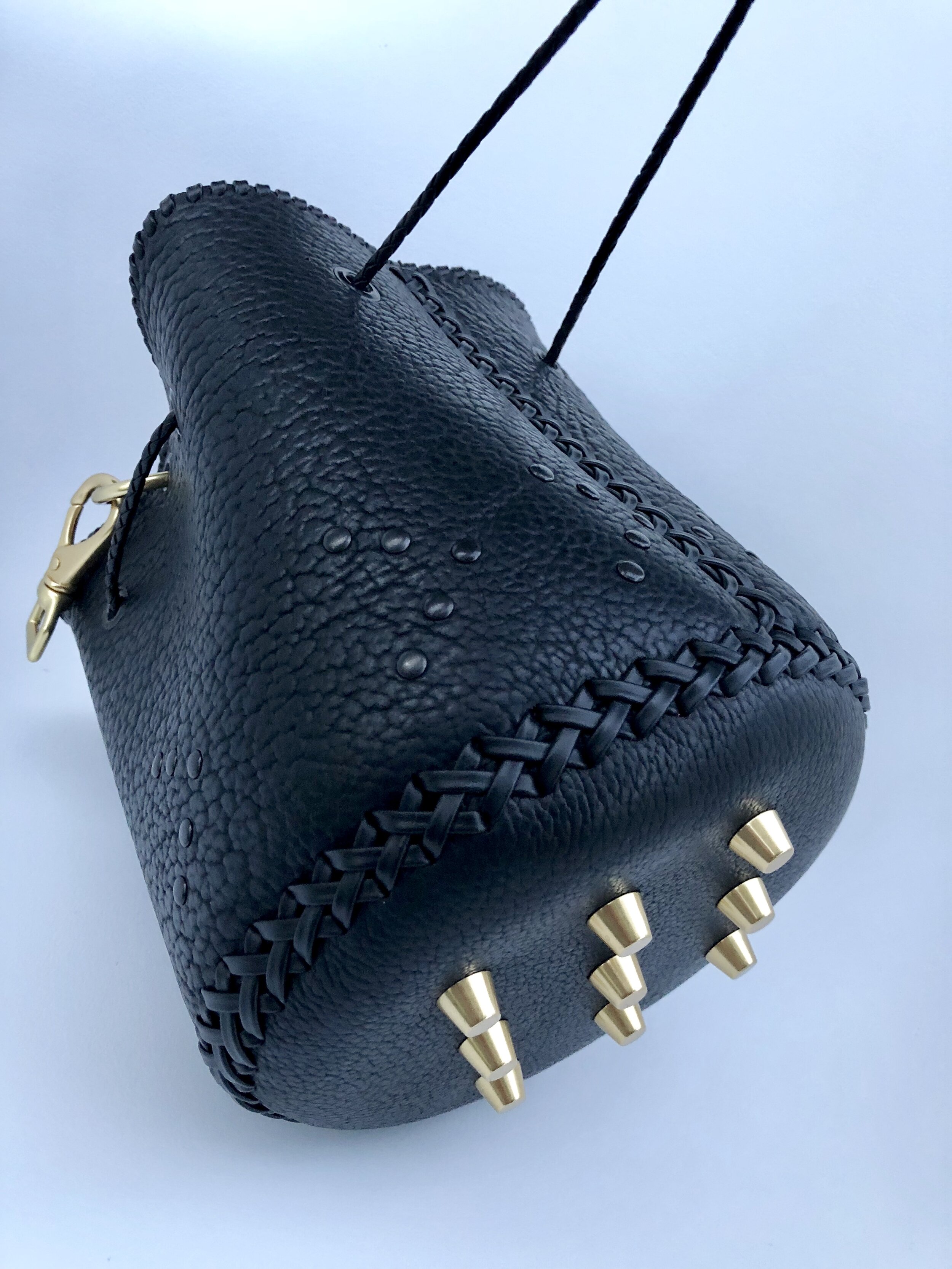 Custom black bison bucket bag with gold bullet feet.