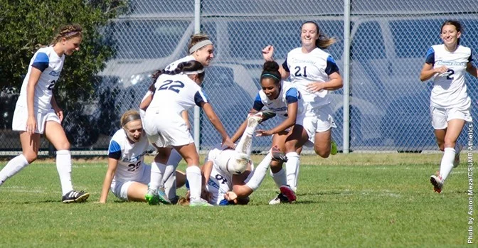 Junior Kristal Luna is rushed by teammates after scoring the game-winning goal against CSUMB. 