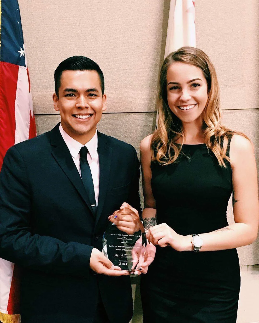 Hinton accepts an award alongside trustee emeritus Jorge Reyes that was received by the CSU Board of Trustees.