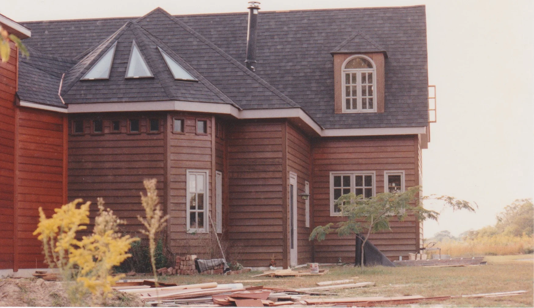 This is the back of the house, with the kitchen on the right and the big room in the middle, and an alcove off the big room. The little windows were made of shades of blue stained glass panes. Above is the north bedroom.