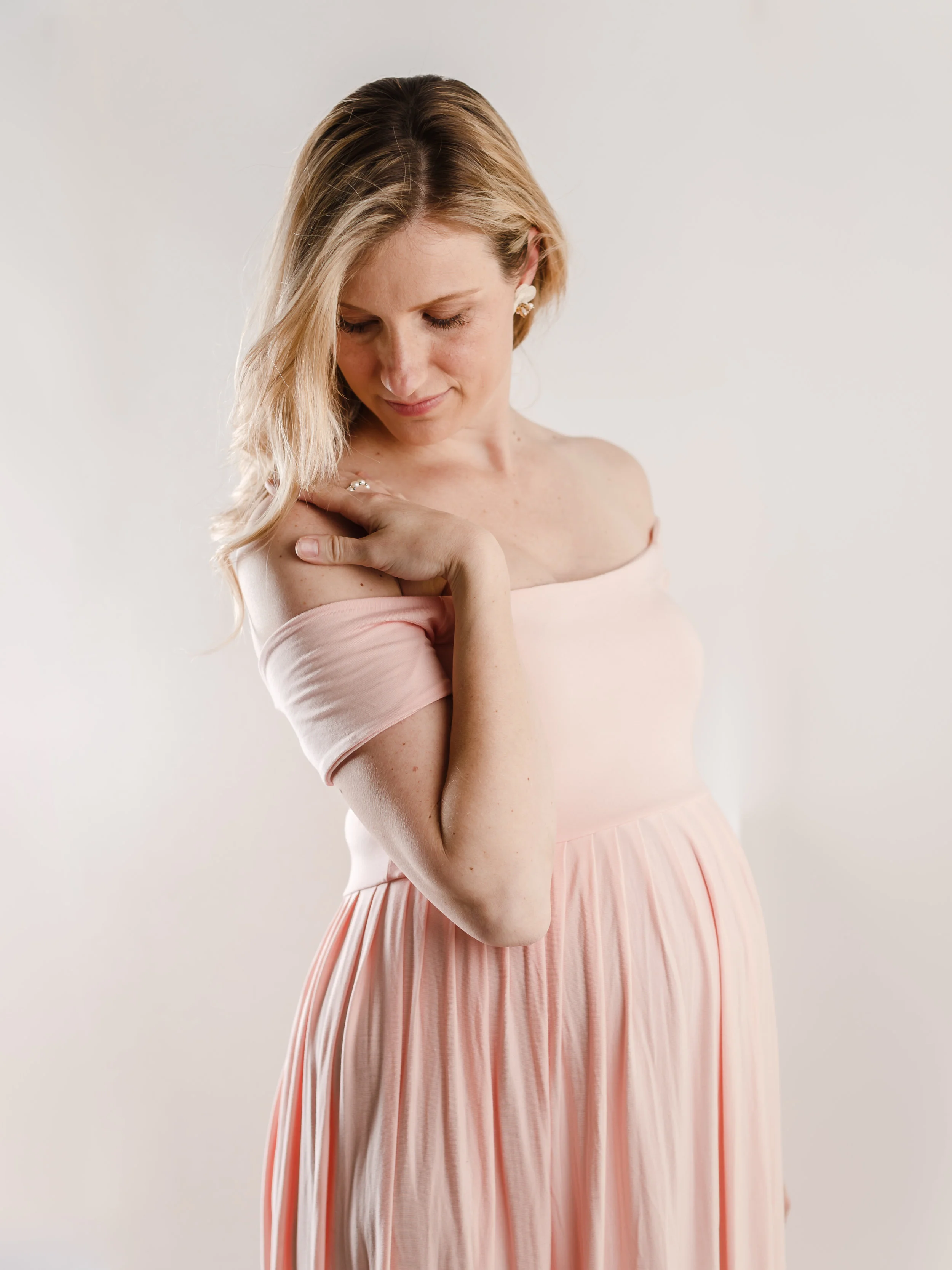 PINK KELLY MAXI GOWN This stunning maxi gown is a fabulous option with the off-the-shoulder short sleeve. An empire waist lends to plenty of room with your baby bump in this comfortable pink knit fabric. Straight top across the bust. Skirt Length | Approx. 58" from under the bust to the floor Skirt Material | Stretch Knit