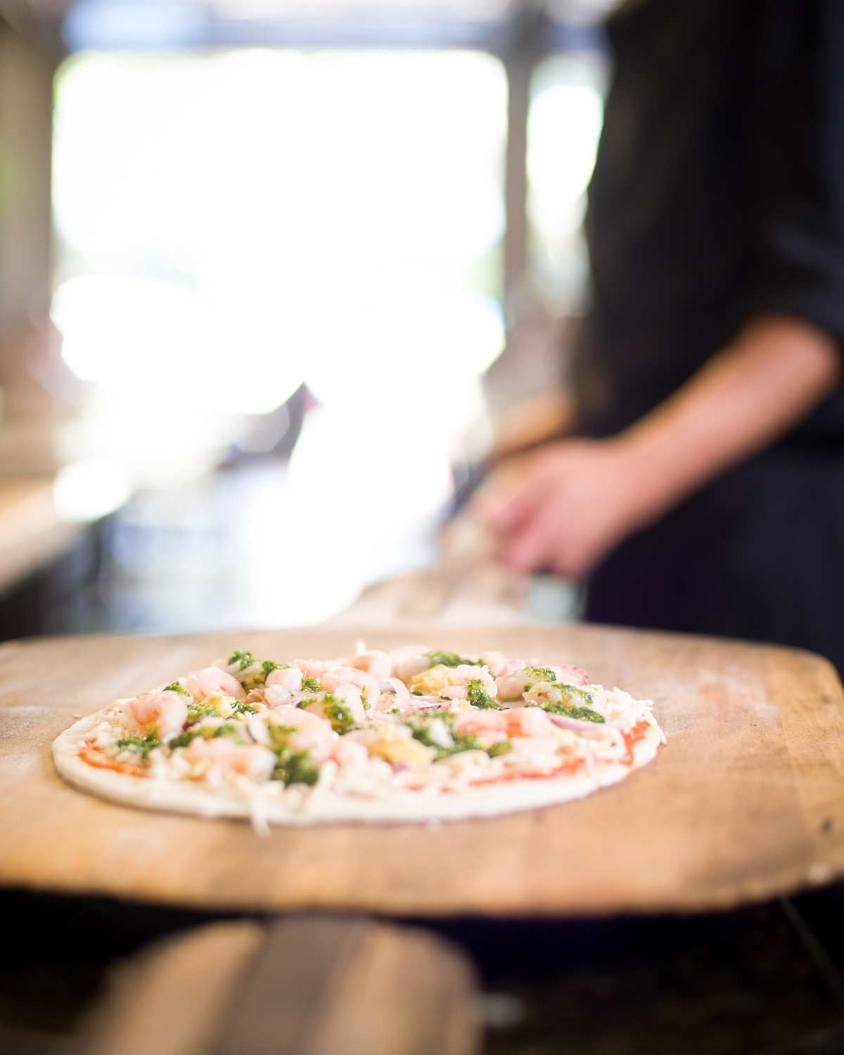 Chef holding uncooked organic shrimp pizza food photograph