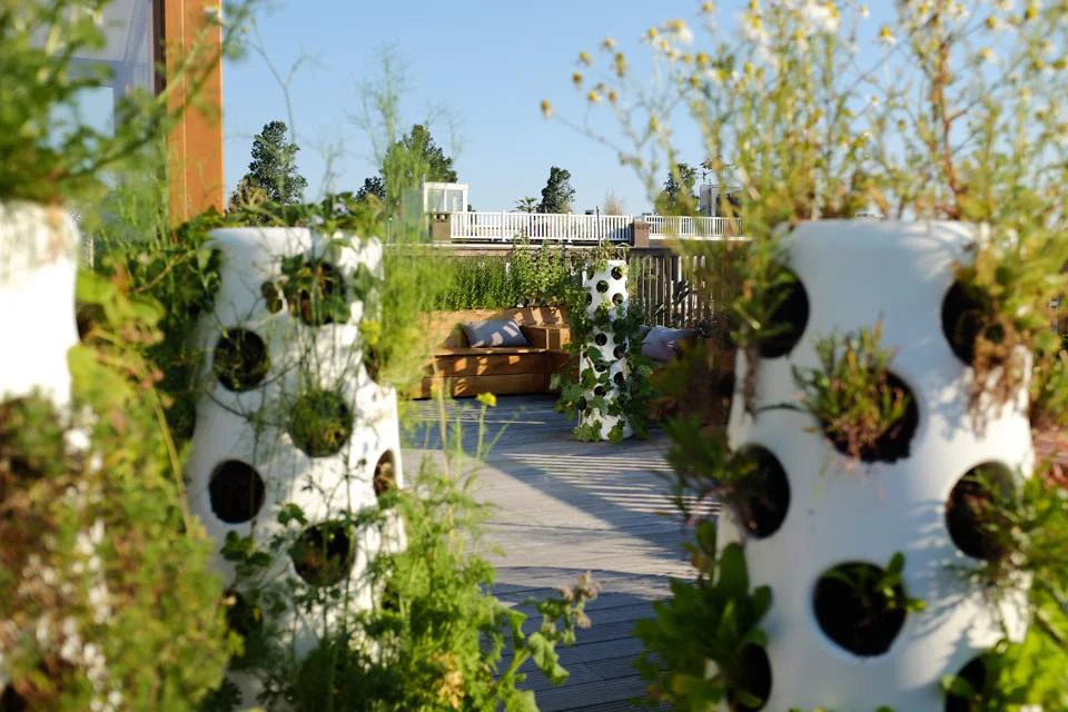 Vertical garden tubes made from recycled plastic. Each tube has space for 48 plants.