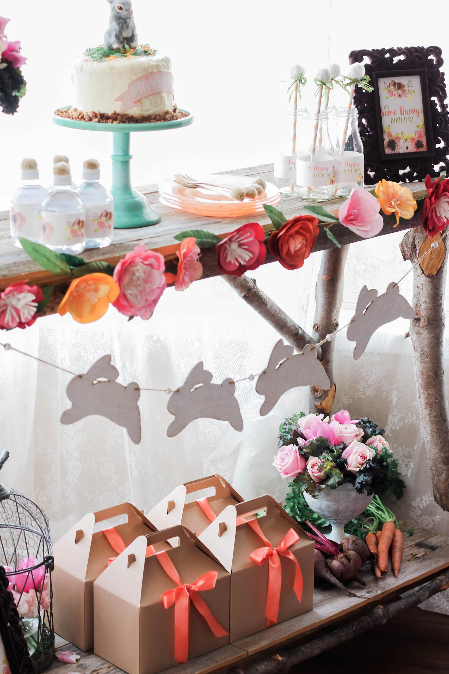 The prettiest display for a Some Bunny Spring Birthday Party - using real vegetables, wooden bunnies for a garland, paper flowers along the table edge . . . click to see more on www.GiggleHearts.com