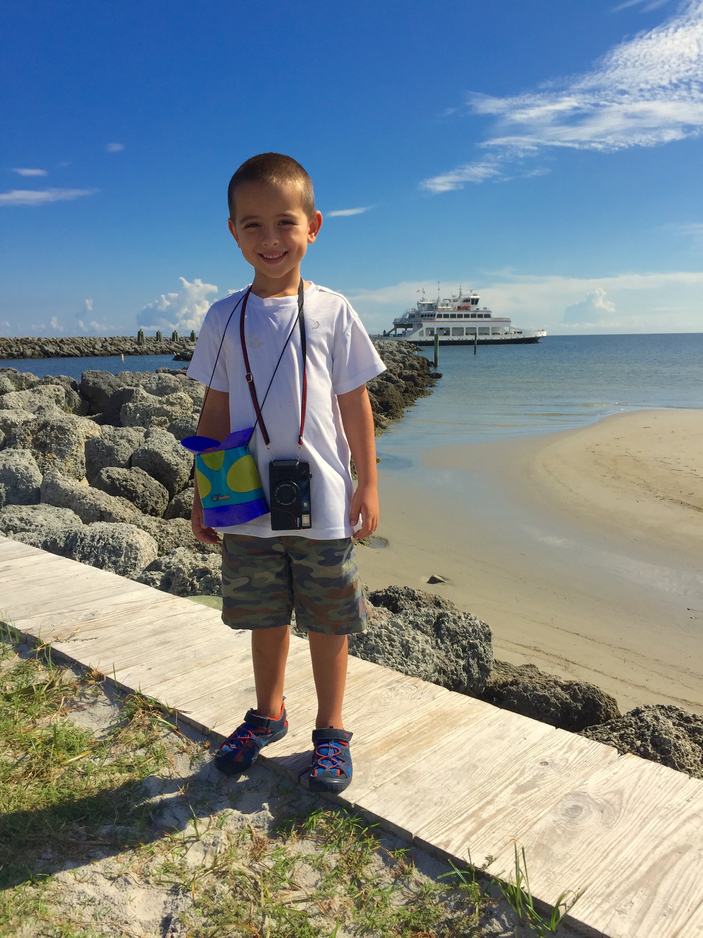 At five years old, adventuring at Cedar Island with his binoculars and 35mm rangefinder. 2015.