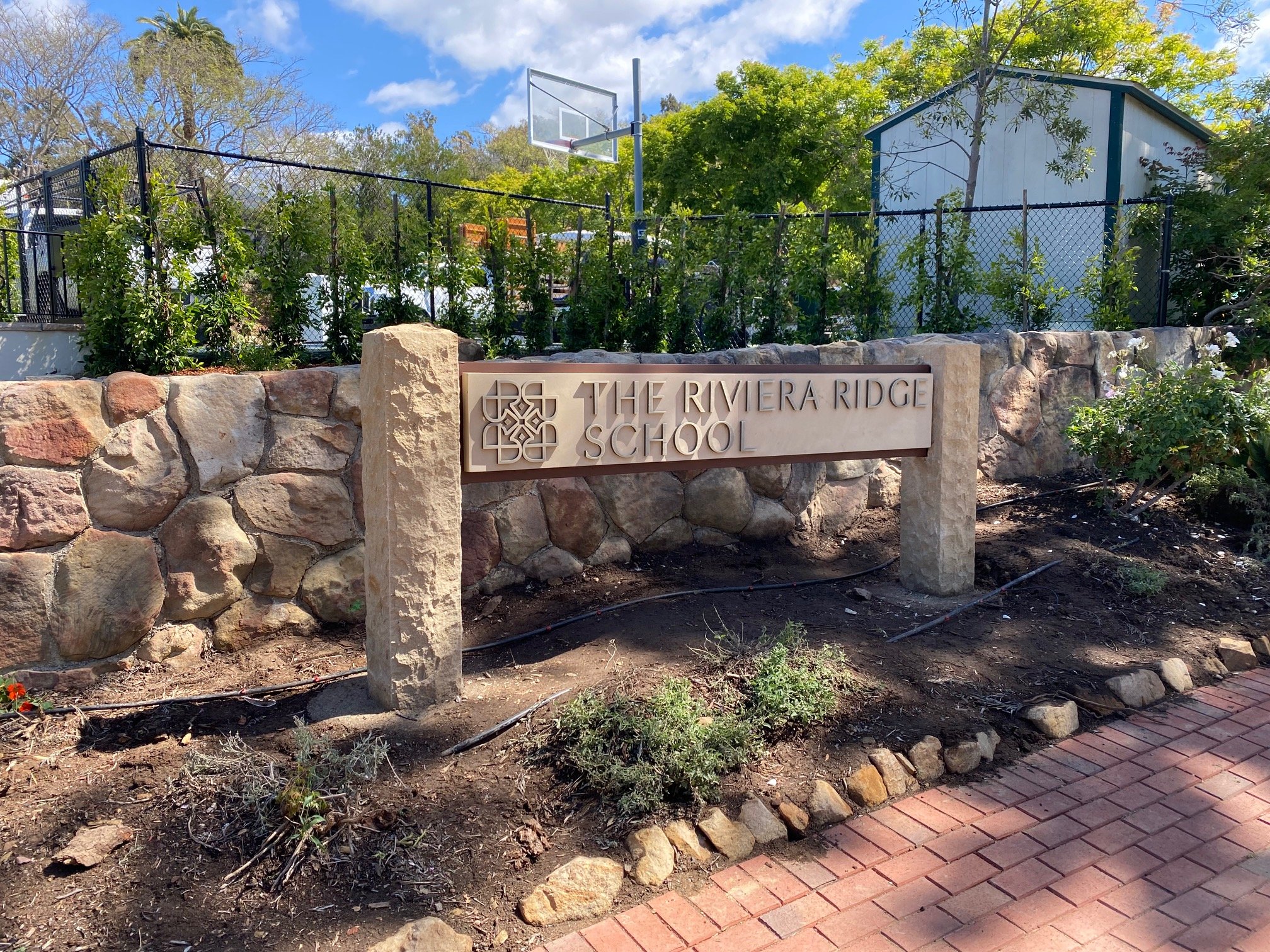 Sandstone and brushed brass lettering