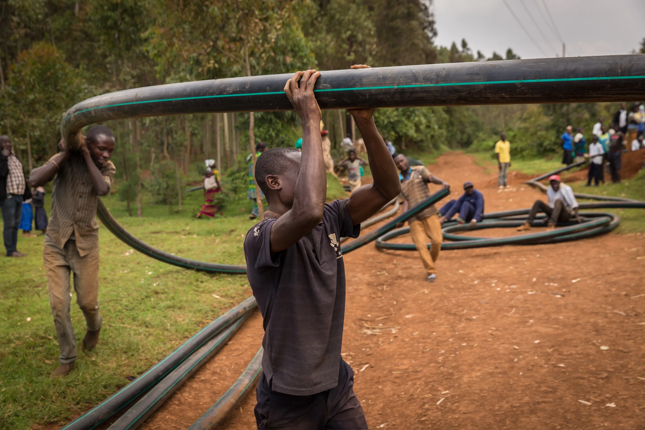 Men carry lengths of water pipeline that will become part of a 30km system that carries fresh, filtered mountain water to Bukavu and outlying, rural areas. 10.22.2017