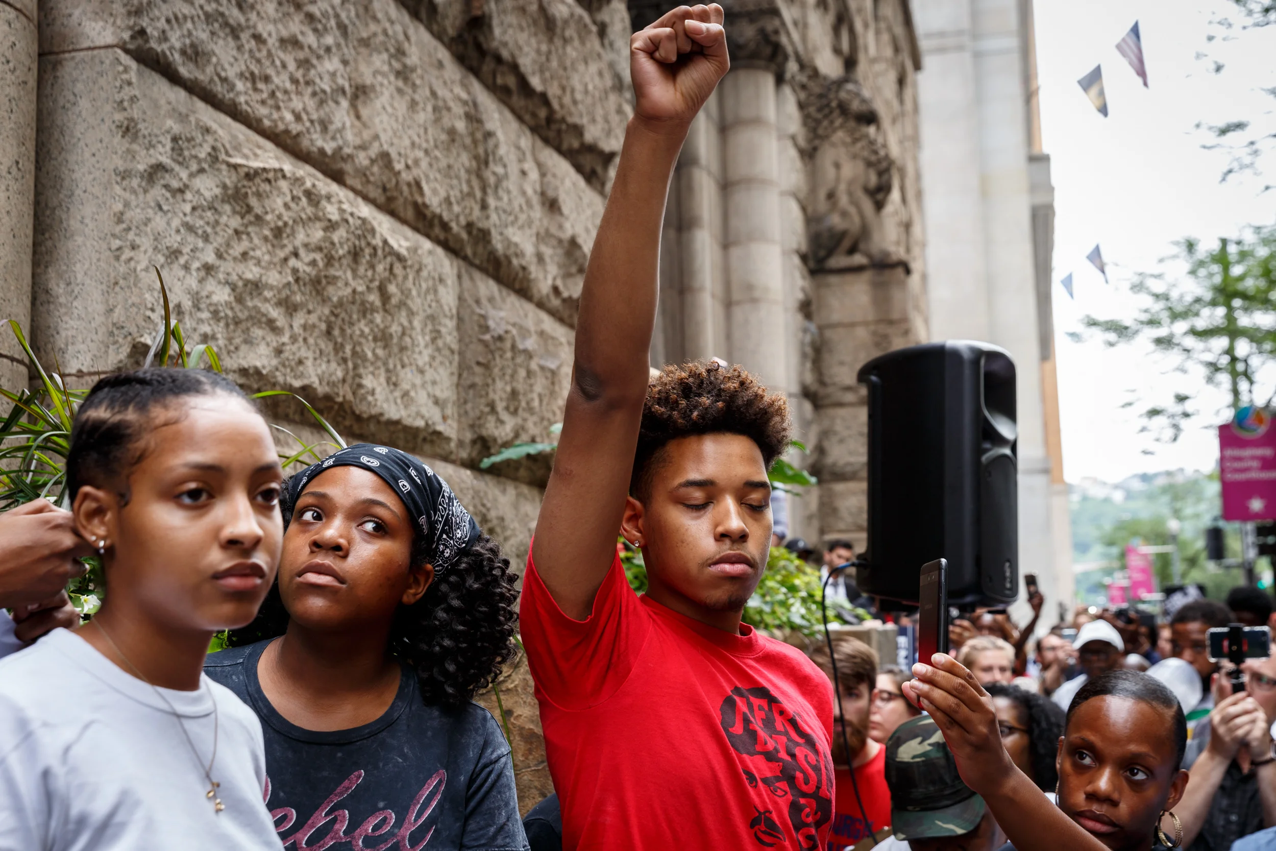 Christian Carter, 18, a member of the Youth Power Collective, raises his fist in the air in protest of Antwon Rose Jr.’s death. Carter later read a poem Antwon wrote: “I wonder what path I will take/I hear that there’s only two ways out/I see mothers bury their sons/I want my mom to never feel that pain.”