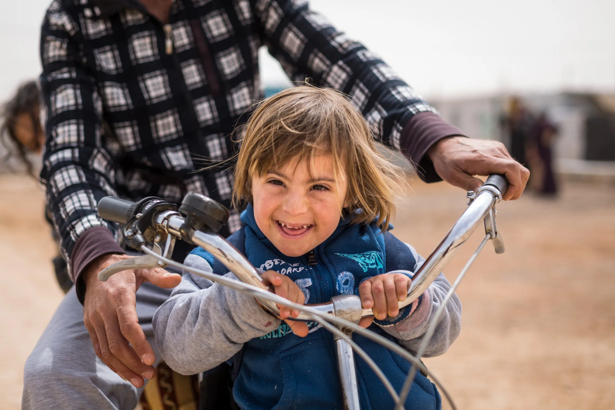 Fatmah, age 6, is one of thousands of children who currently call the Zaatari Refugee Camp home. According to a UNHCR report the population of Zaatari hovers right around 80,000 with over half of that number being children and 20% under the age of 5. Fatmah came to the camp with her family in late 2013 -- she enjoys bike rides and playing with some of the other children in the camp.