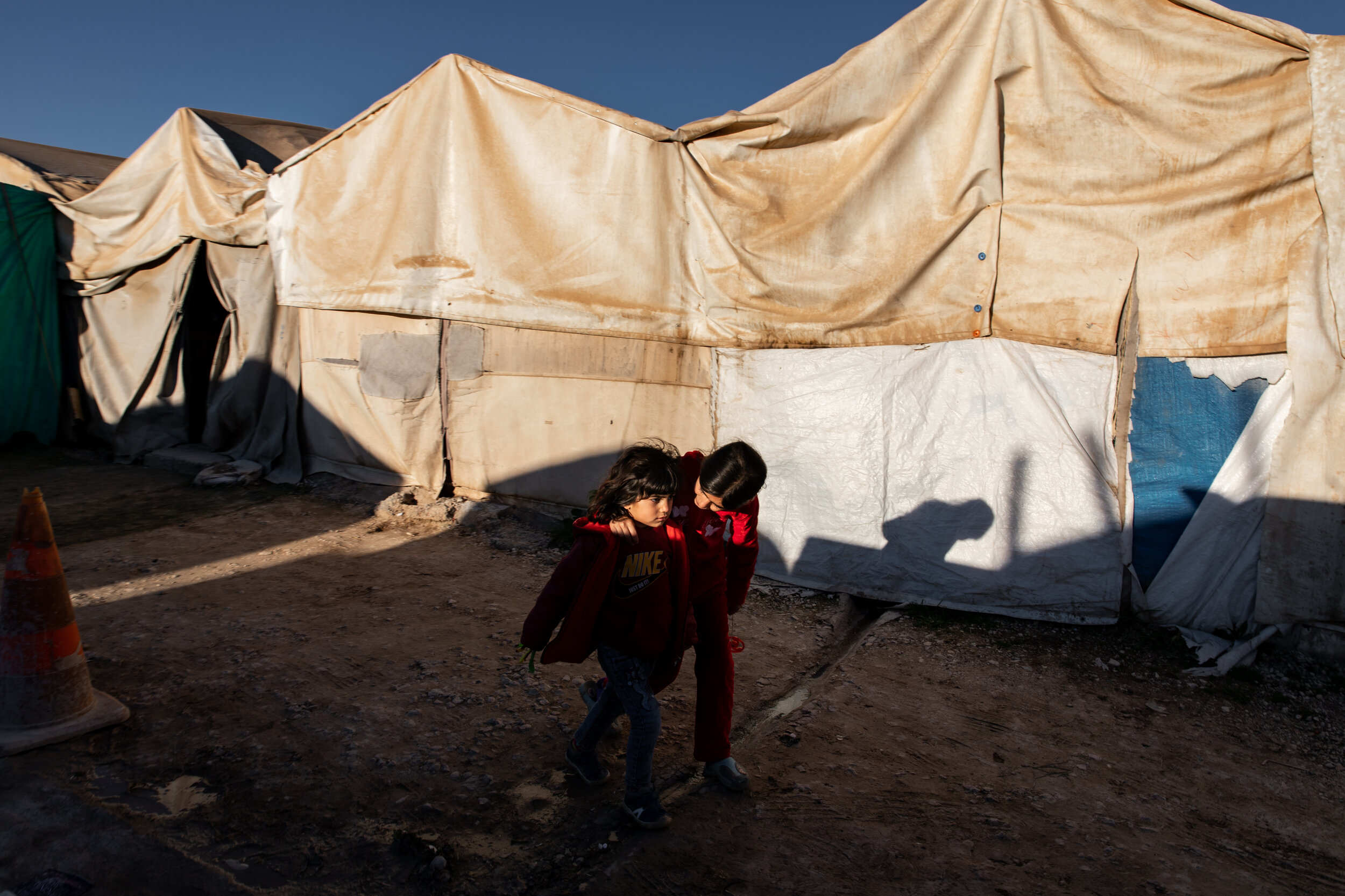 Ghalya comforts her cousin Nerows as they walk to the small market within the Shariya Yazidi Displacement Camp in Iraqi Kurdistan.