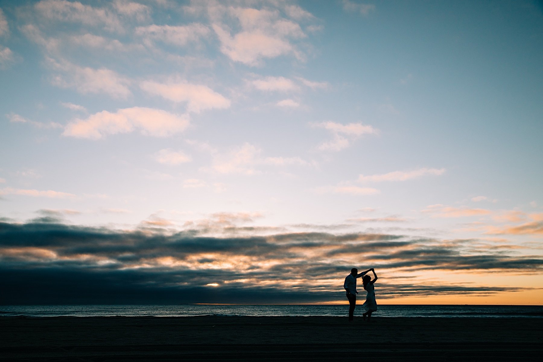 07_dancing during sunrise engagement session on the beach.jpg