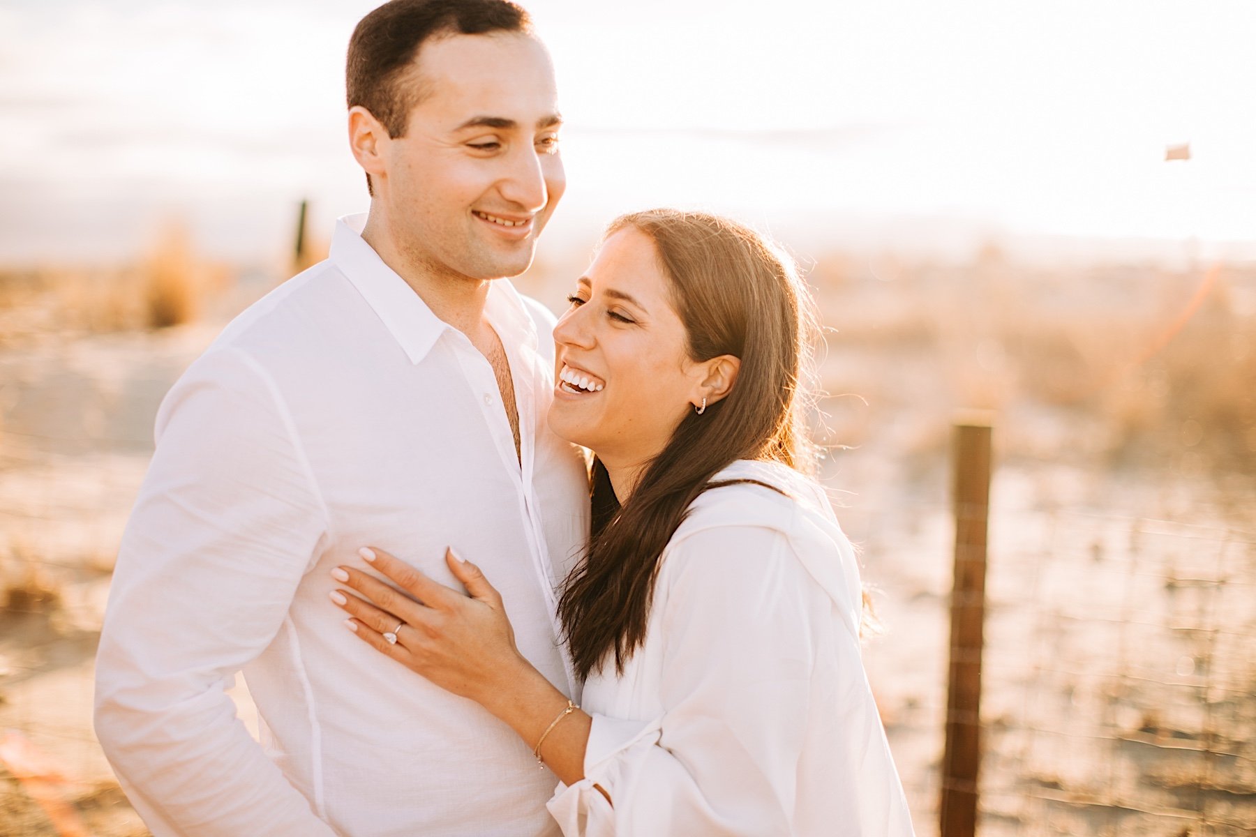 16_couple laughing during beach sunrise session sandy hook.jpg