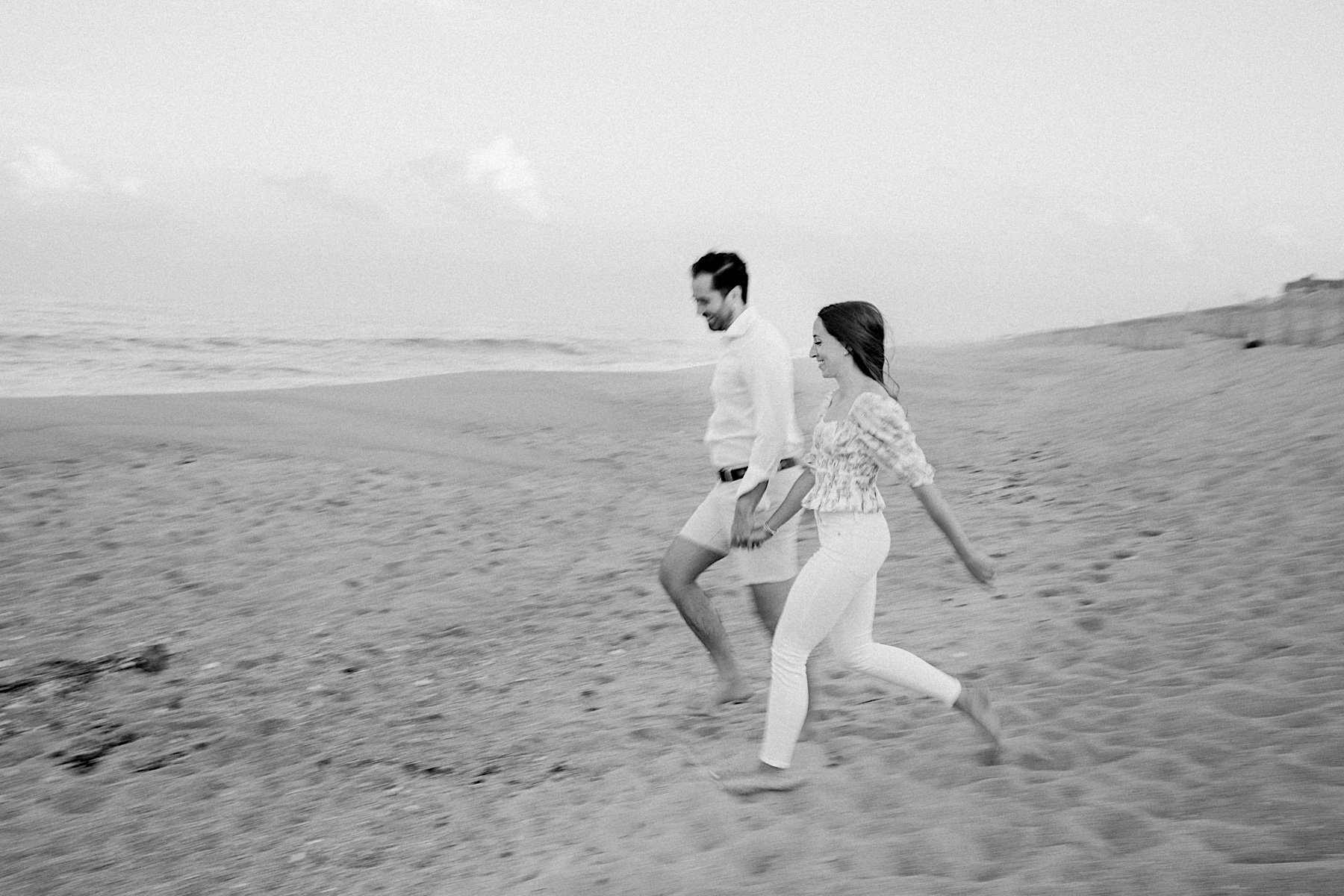 12_couple running on the beach engagement session.jpg