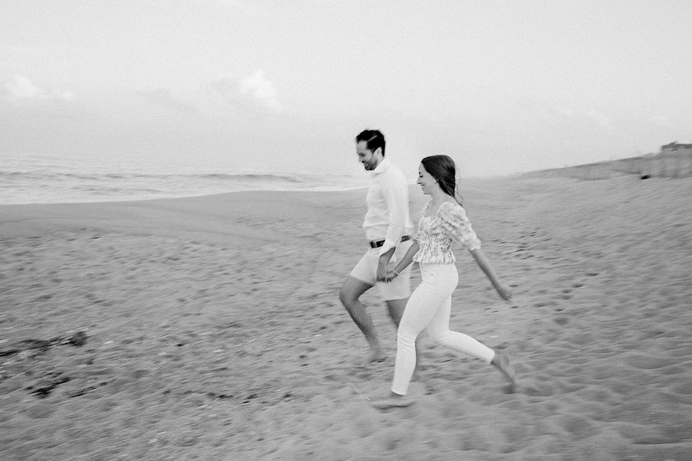 12_couple running on the beach engagement session.jpg