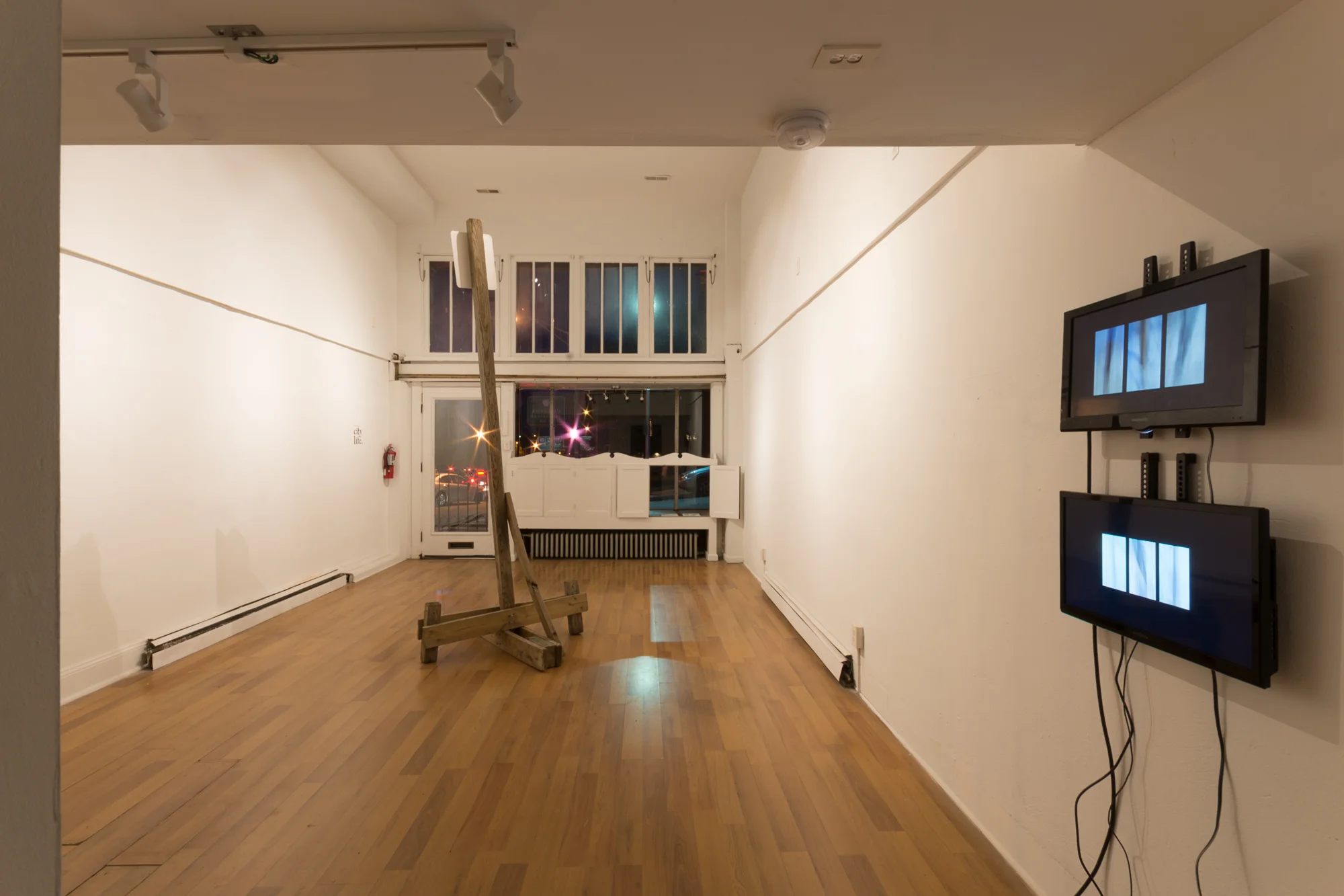 Installation view featuring: Twisted Sign Posts II & III, 2017. Video. 09:21 min. and Temporary Street Sign, 2017.