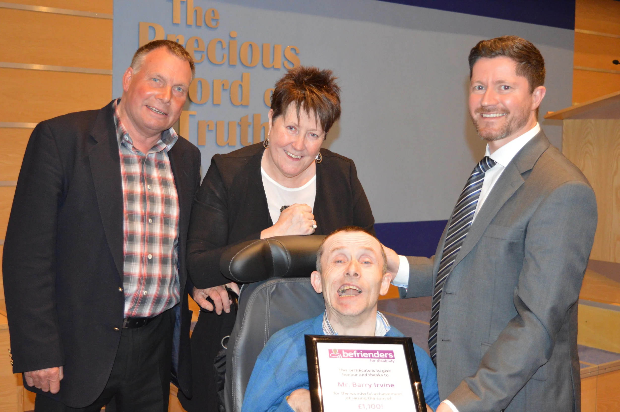 Barry (centre foreground) with Raymond (left) who drives the bus he takes to get to church and was instrumental in helping to secure sponsorship. Barry was presented with his certificate by Mrs Terry Fairfowl (centre) and Pastor David Murray, two of the Directors of Befrienders For Disability.