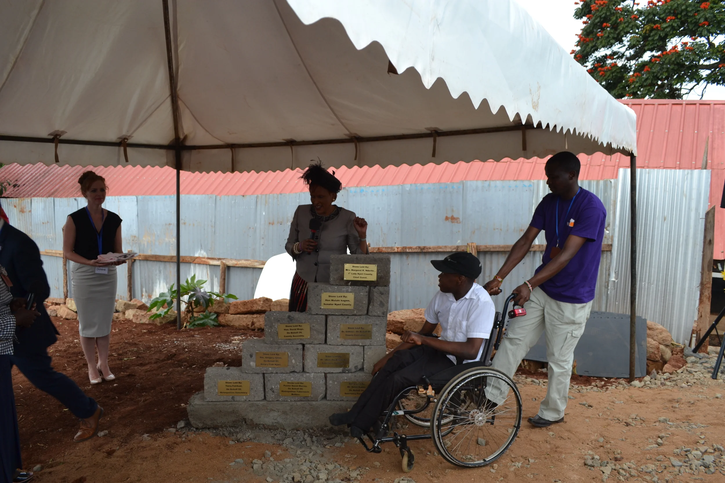 The First Lady of Nyeri County lays a foundation stone, accompanied by Dennis who attends the Metropolitan Sanctuary for therapy and day care. 