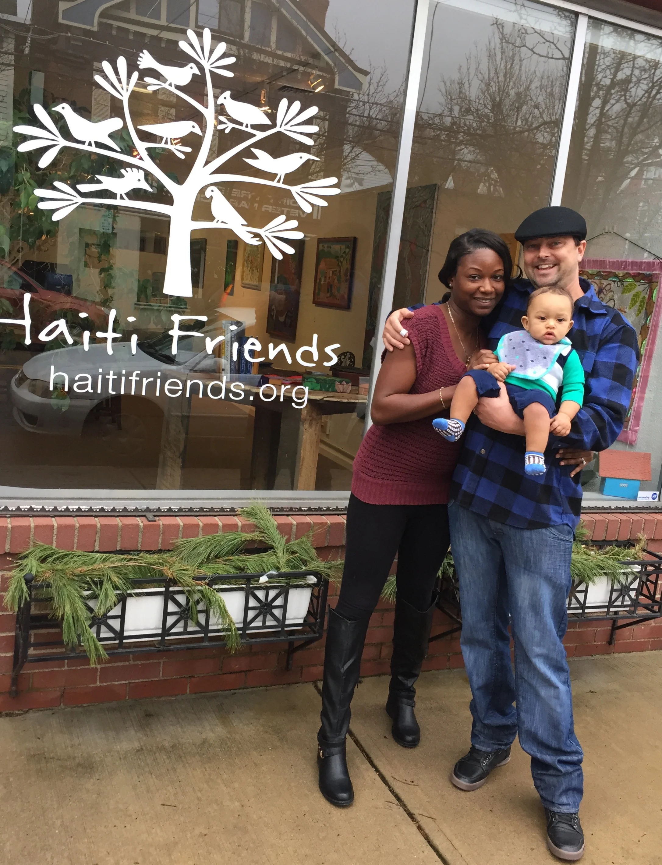 Executive Director Edward Rawson, his wife Lidia, and their son Olivier in front of the new sign at the gallery on Reynolds St. 