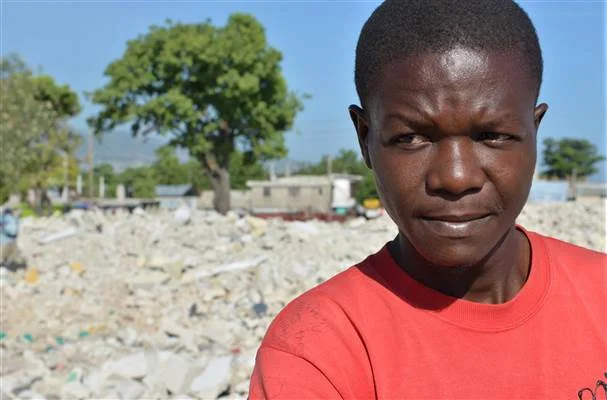 Jean-Louis Wilner stands on the rubble of his demolished neighborhood in central Port-au-Prince, Haiti, July 7, 2014