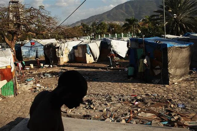 A man walks past a camp for people displaced by the earthquake on March 4, 2012 in Port-au-Prince.