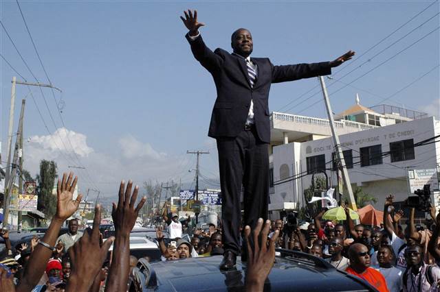 Haiti hip-hop star Wyclef Jean greets the crowd before officially registering as a presidential candidate at an office in the Delmas neighborhood of Port-au-Prince in 2010.