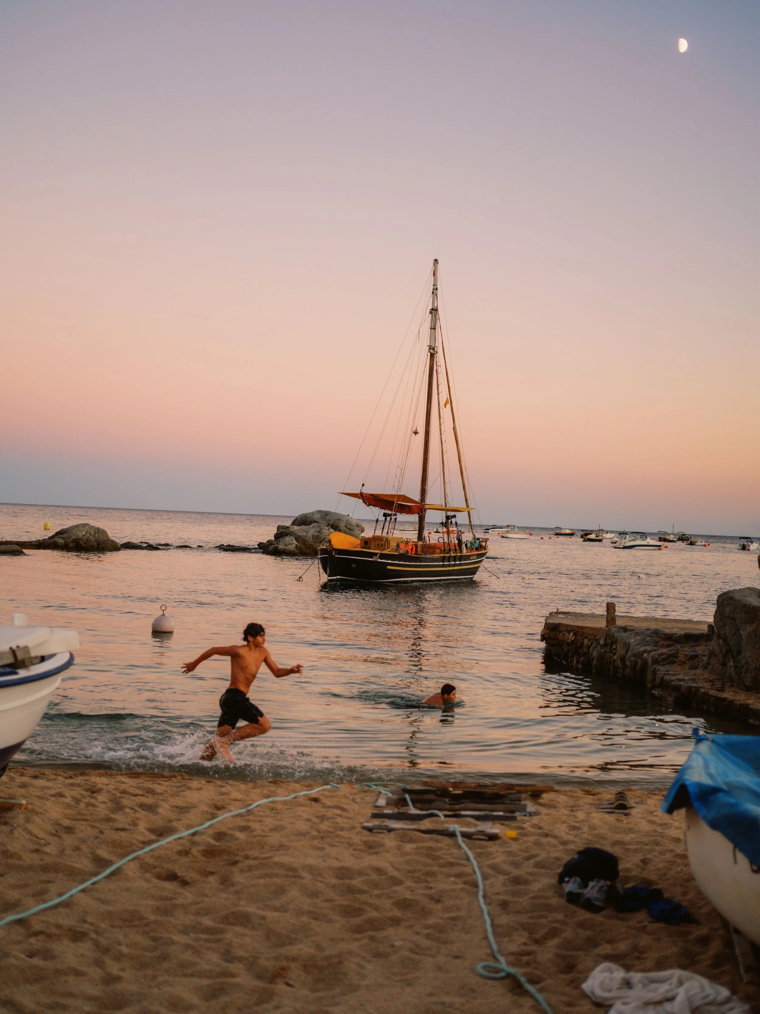 kid running on the beach at sunset calella de palafrugell