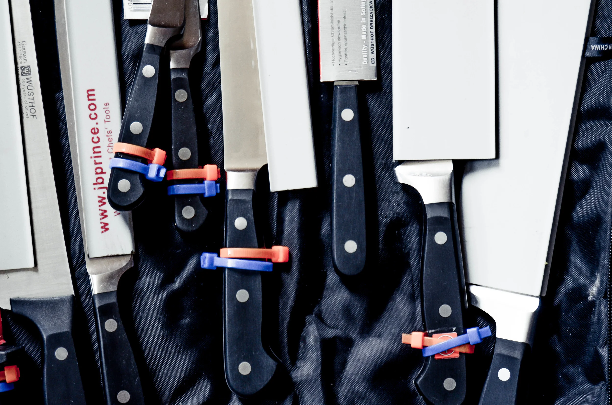 left to right: chef's 10" knife, filet knife, tourne, paring, santoku, turning fork, boning, bread.