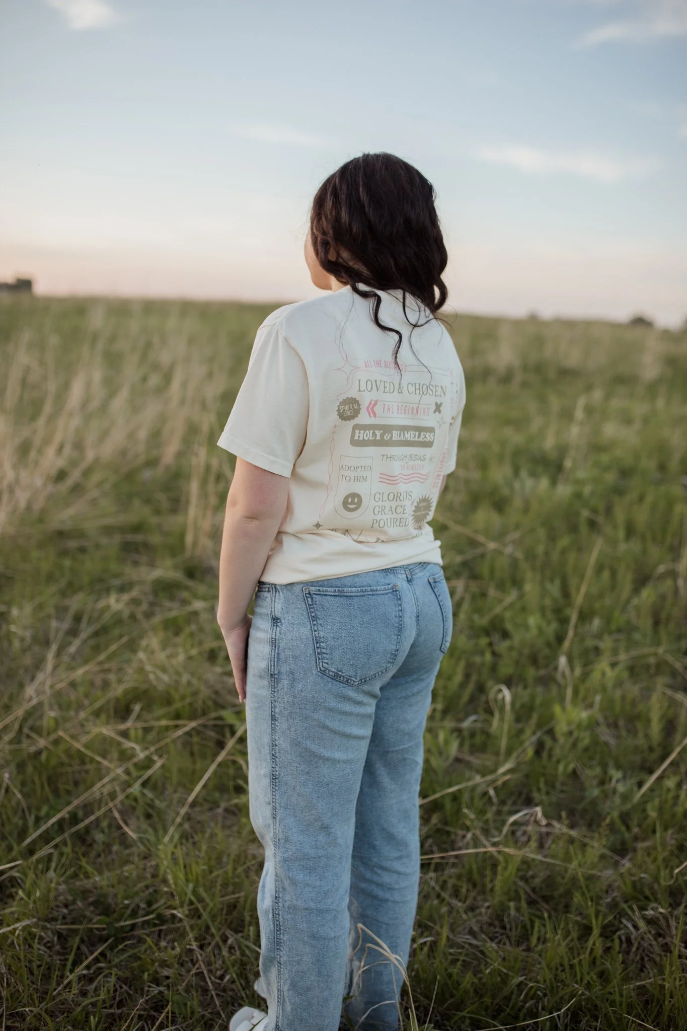 Christian comfort colors True Identity in Christ T-shirt inspired by bible verse Ephesians 1:3-8.  ivory tee with pink and tan screen print reminding believers that they are deeply chosen and loved.