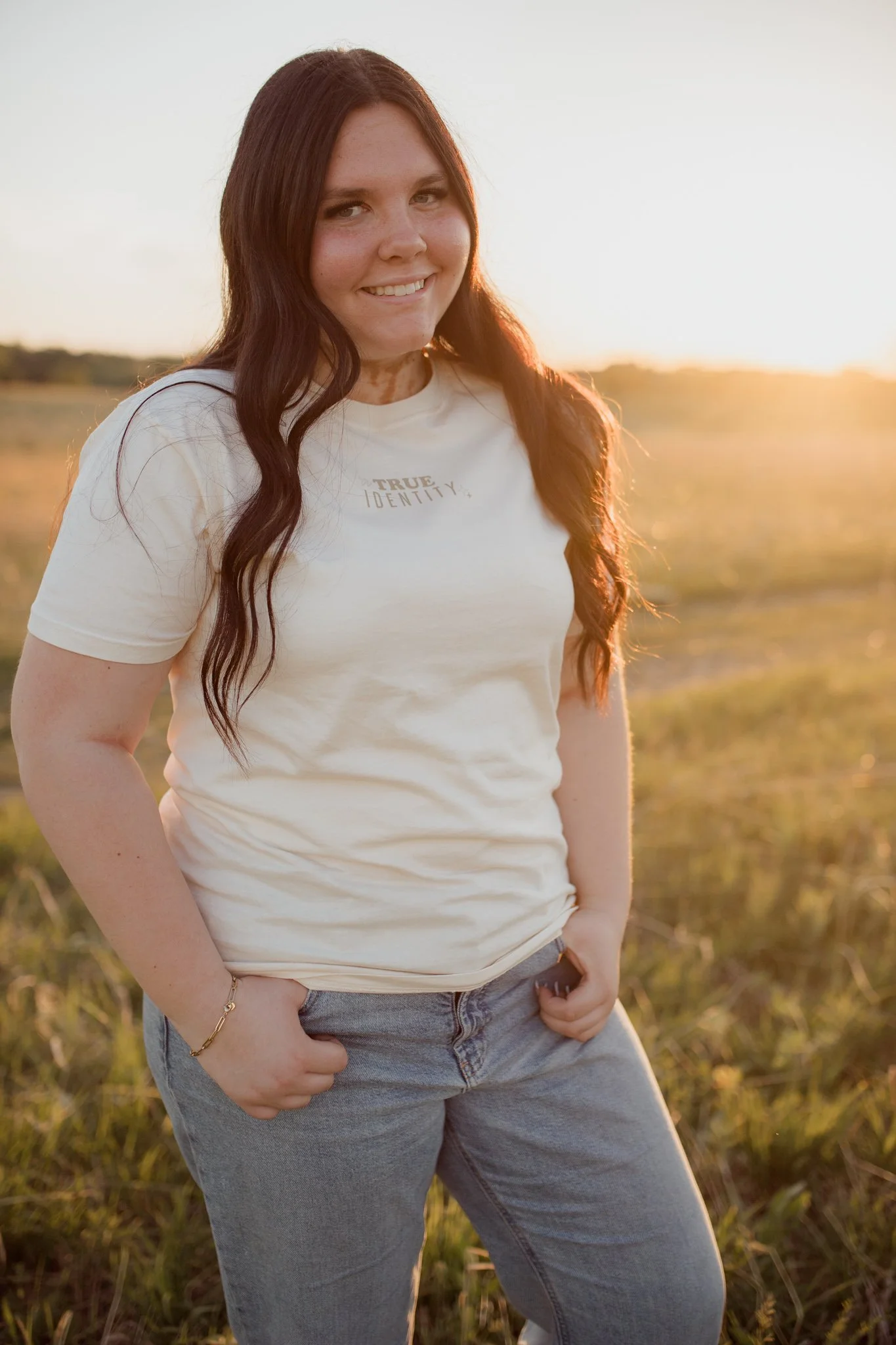 Christian comfort colors True Identity in Christ T-shirt inspired by bible verse Ephesians 1:3-8.  ivory tee with pink and tan screen print reminding believers that they are deeply chosen and loved.