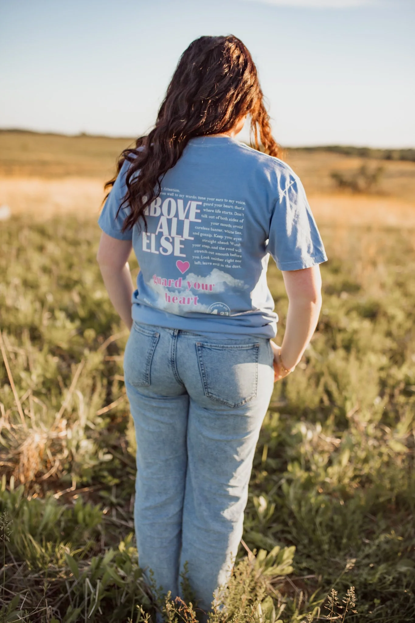 Christian comfort colors Above All else T-shirt inspired by bible verse proverbs 4:23.  blue denim tee with pink and white screen print reminding believers to guard your heart