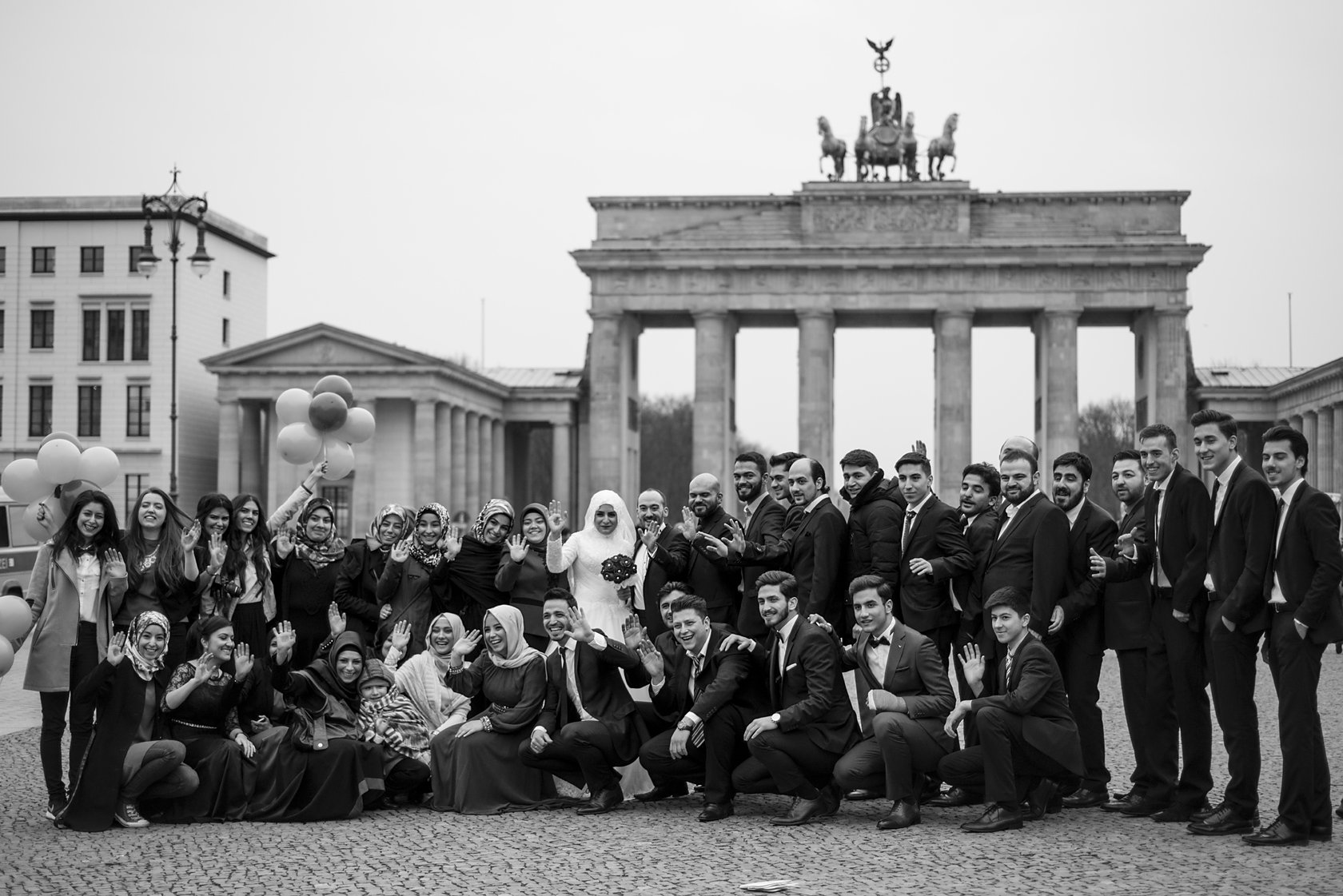  Large group of young people posing in front of the Brandenburg Gate, Berlin. Street photograph by Chris Perona. 