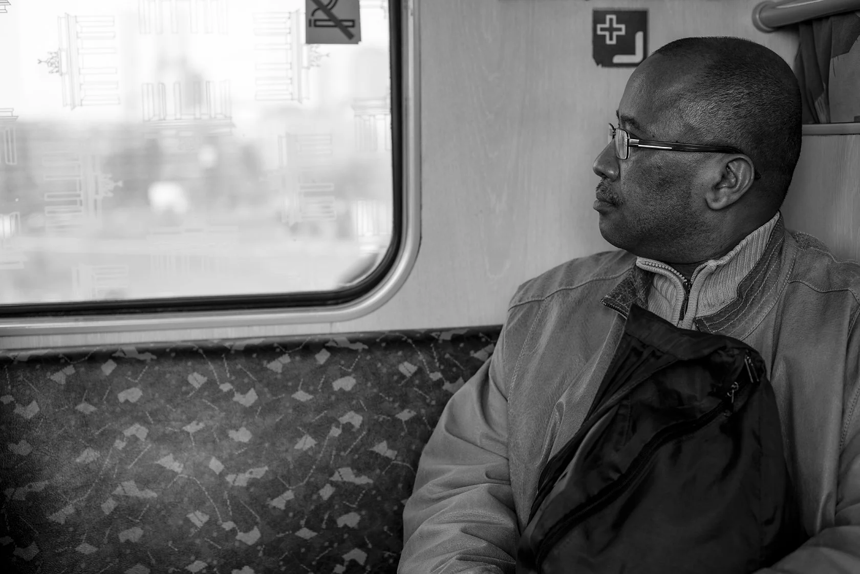  Man with glasses looking out of an S-Bahn window, Berlin. Candid street portrait by Chris Perona. 