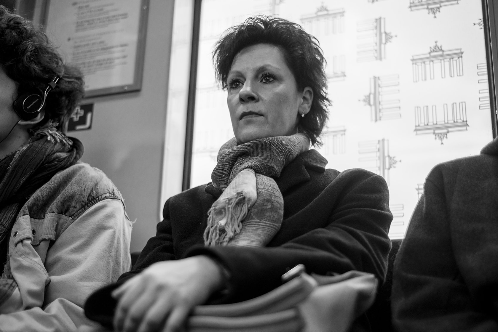  Woman in a scarf seated on a Berlin U-Bahn, gazing ahead. Candid street portrait by Chris Perona. 