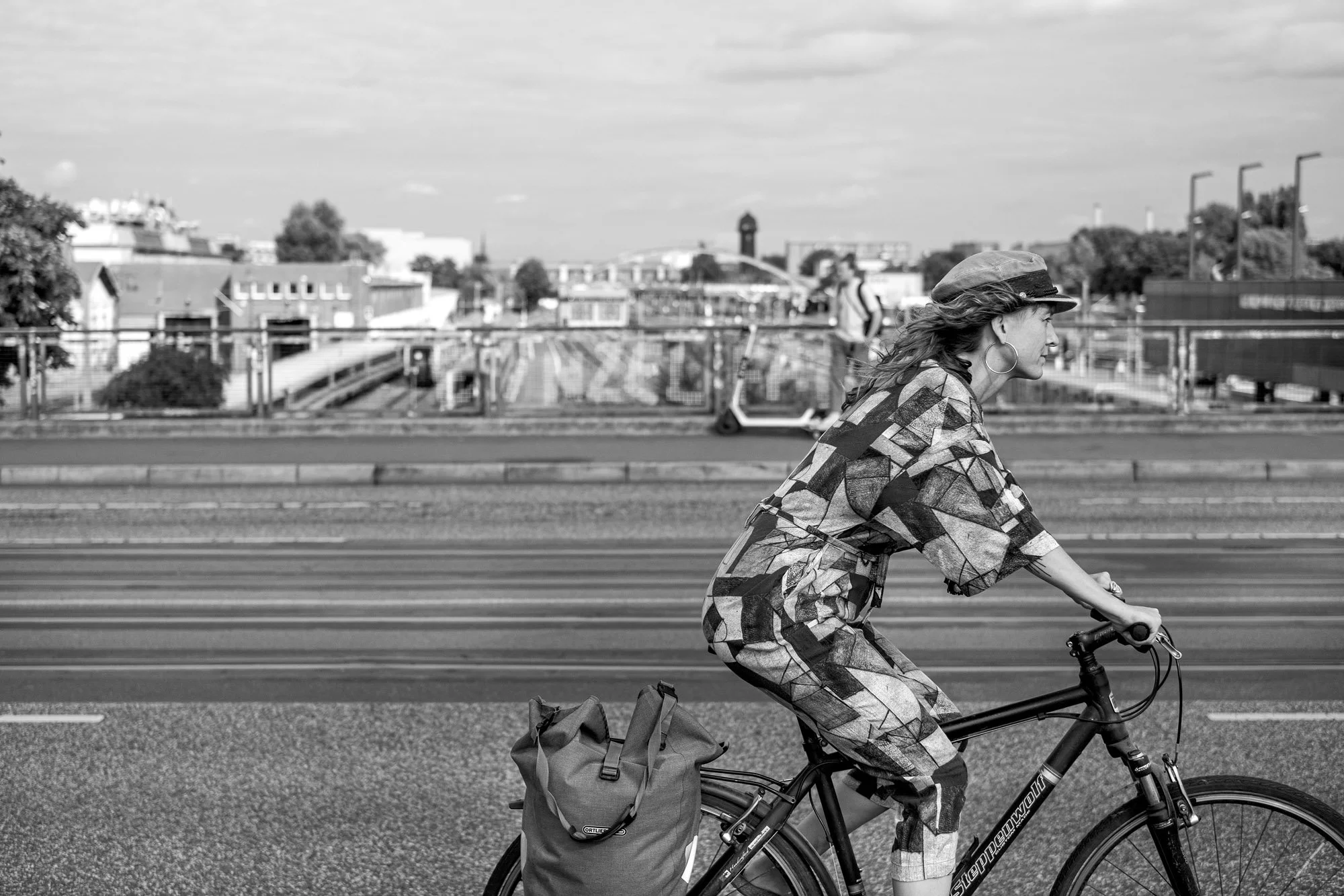  Woman cycling with a small dog in her bike basket, Berlin. Candid street portrait by Chris Perona. 
