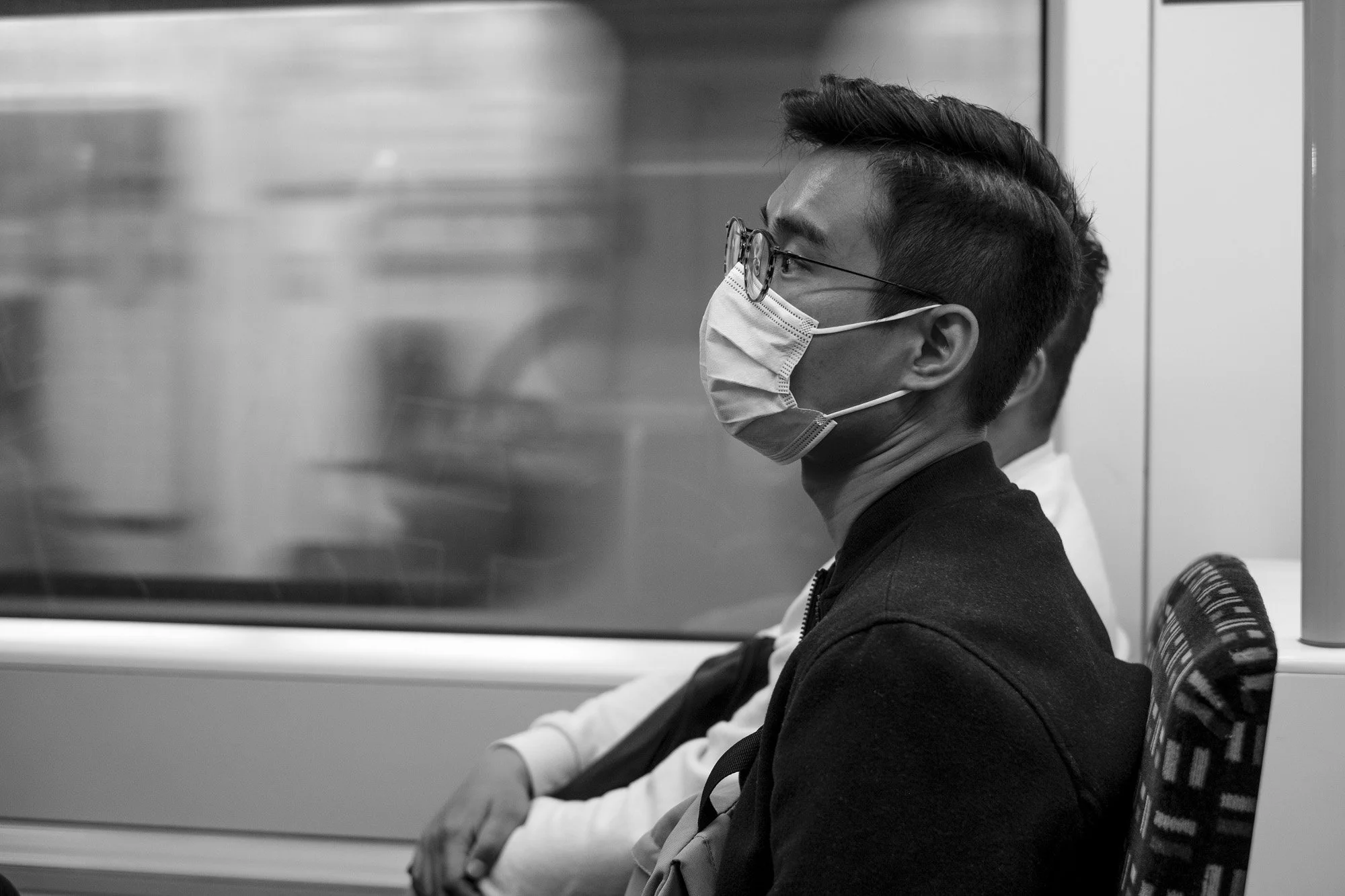  Young man in a face mask riding the Tube, London. Candid street portrait by Chris Perona. 