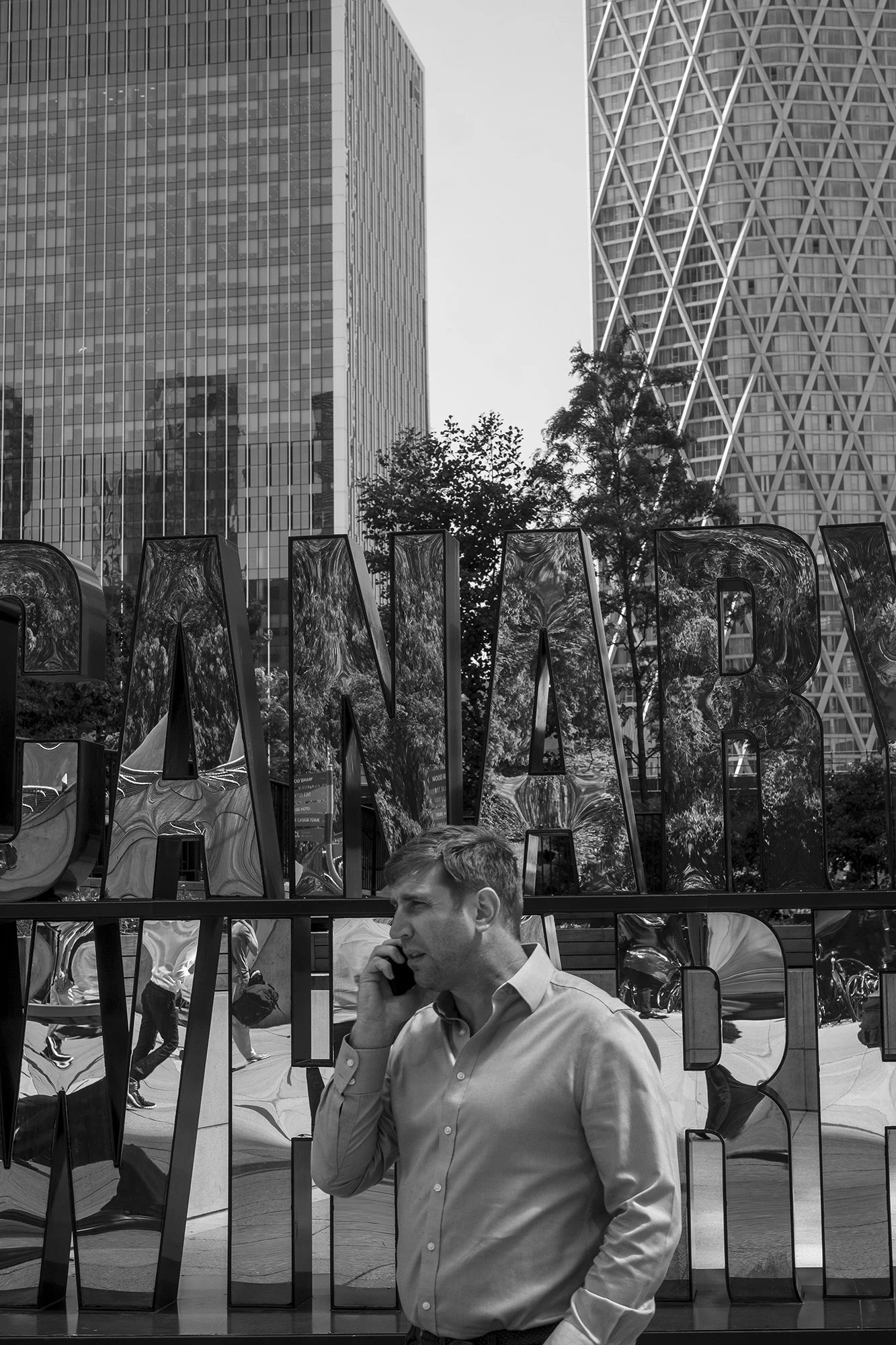  Man on the phone among glass office towers, London. Candid street portrait by Chris Perona. 