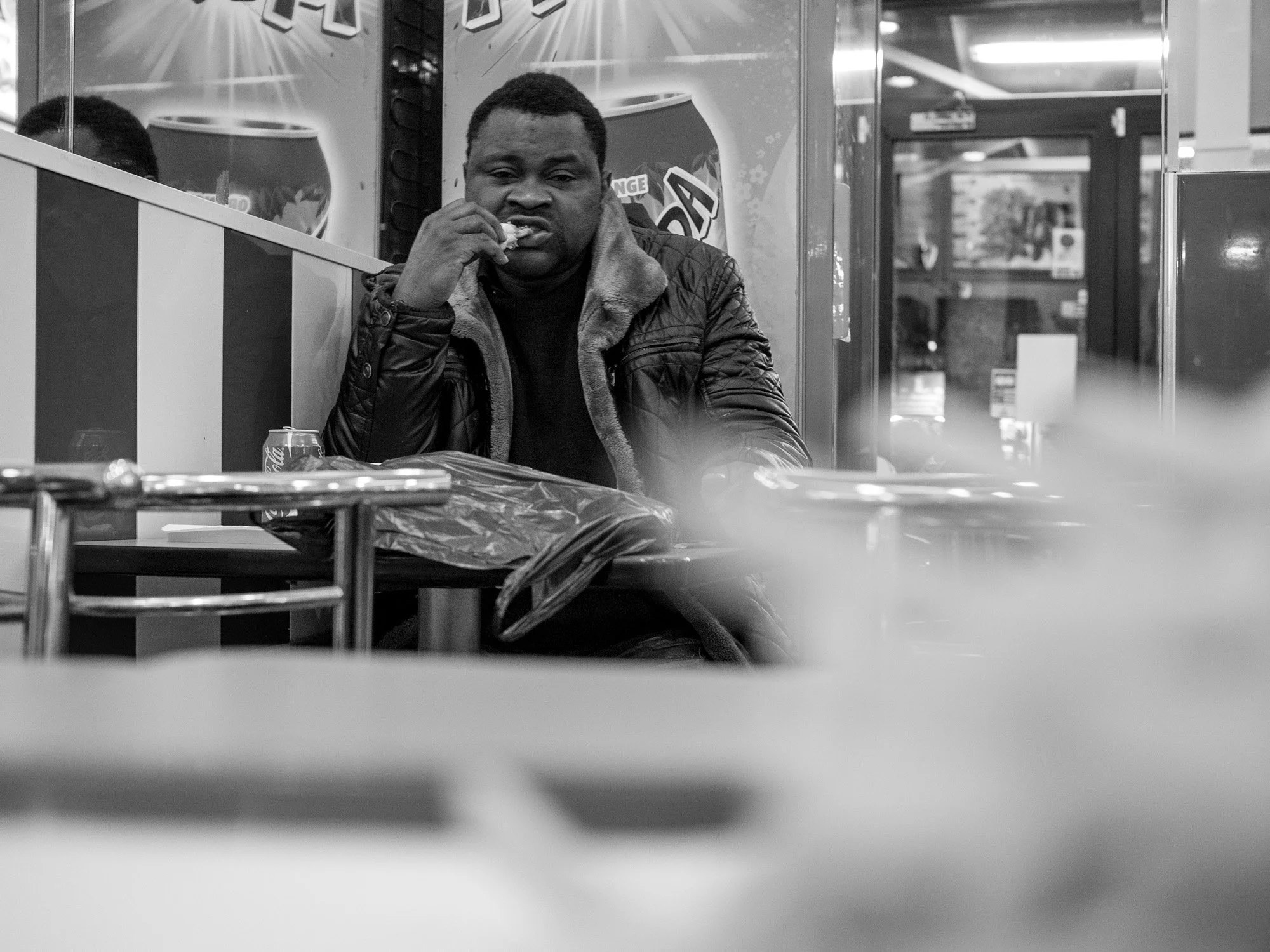  Man eating at a table in a Paris brasserie. Candid street portrait by Chris Perona. 