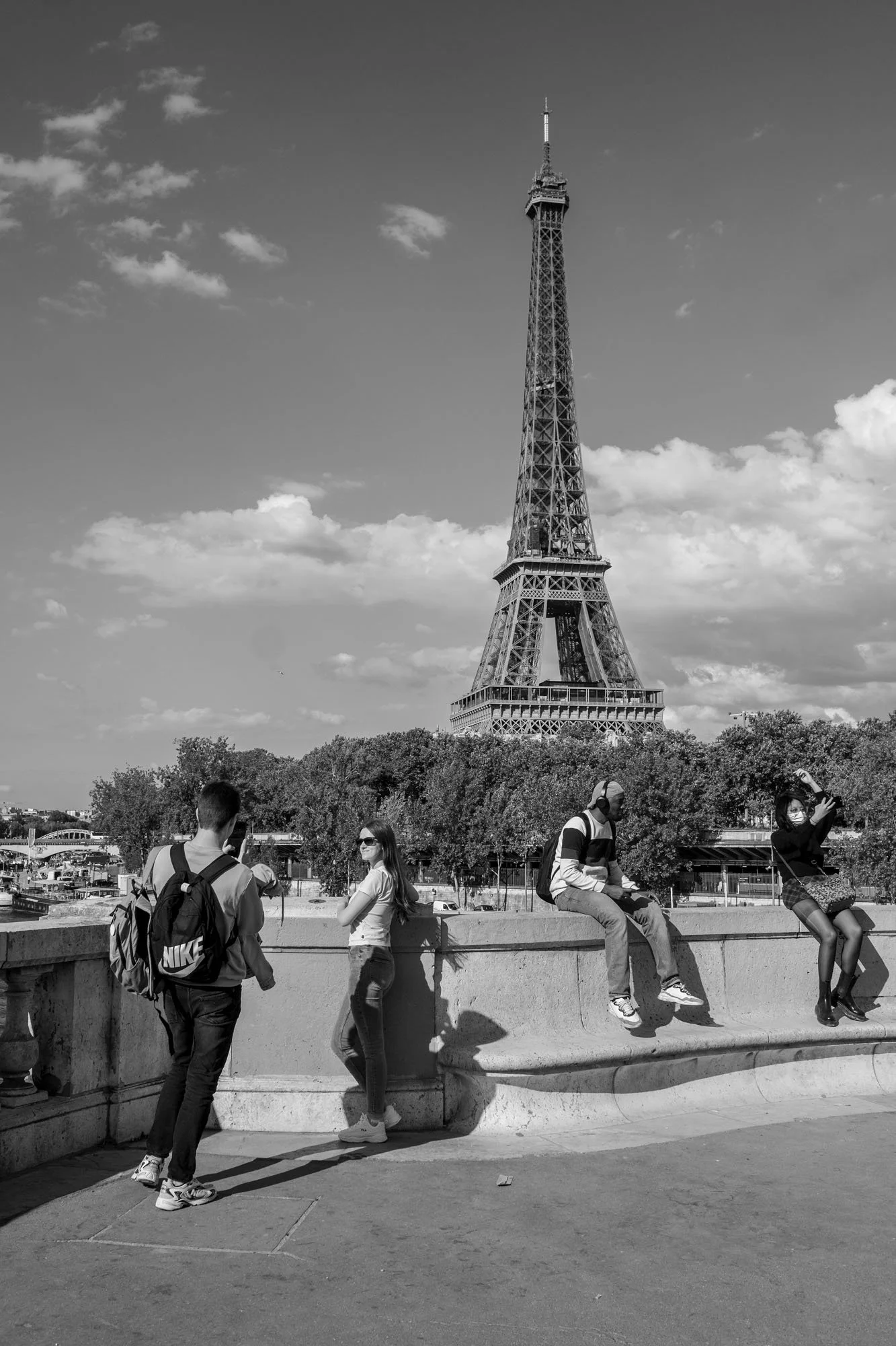  Young people posing on the parapet in front of the Eiffel Tower, Pont de Bir-Hakeim, Paris. Street photograph by Chris Perona. 