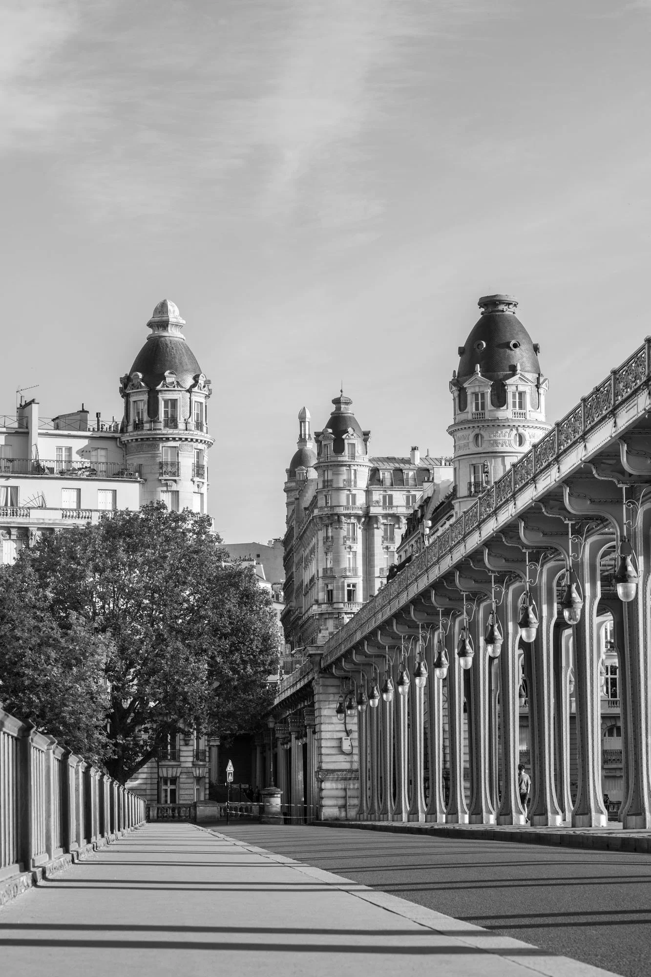  Empty walkway beneath the iron colonnade, Haussmann buildings of Passy behind, Pont de Bir-Hakeim, Paris. Architecture photograph by Chris Perona. 