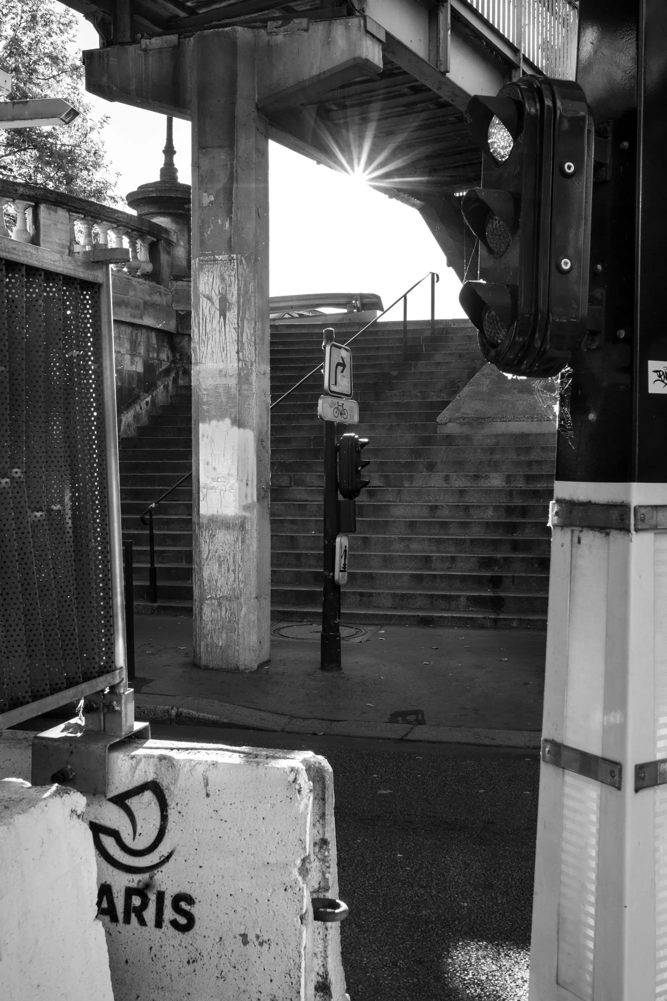  Sunburst through the iron structure above a stairway, Pont de Bir-Hakeim, Paris. Architecture photograph by Chris Perona. 