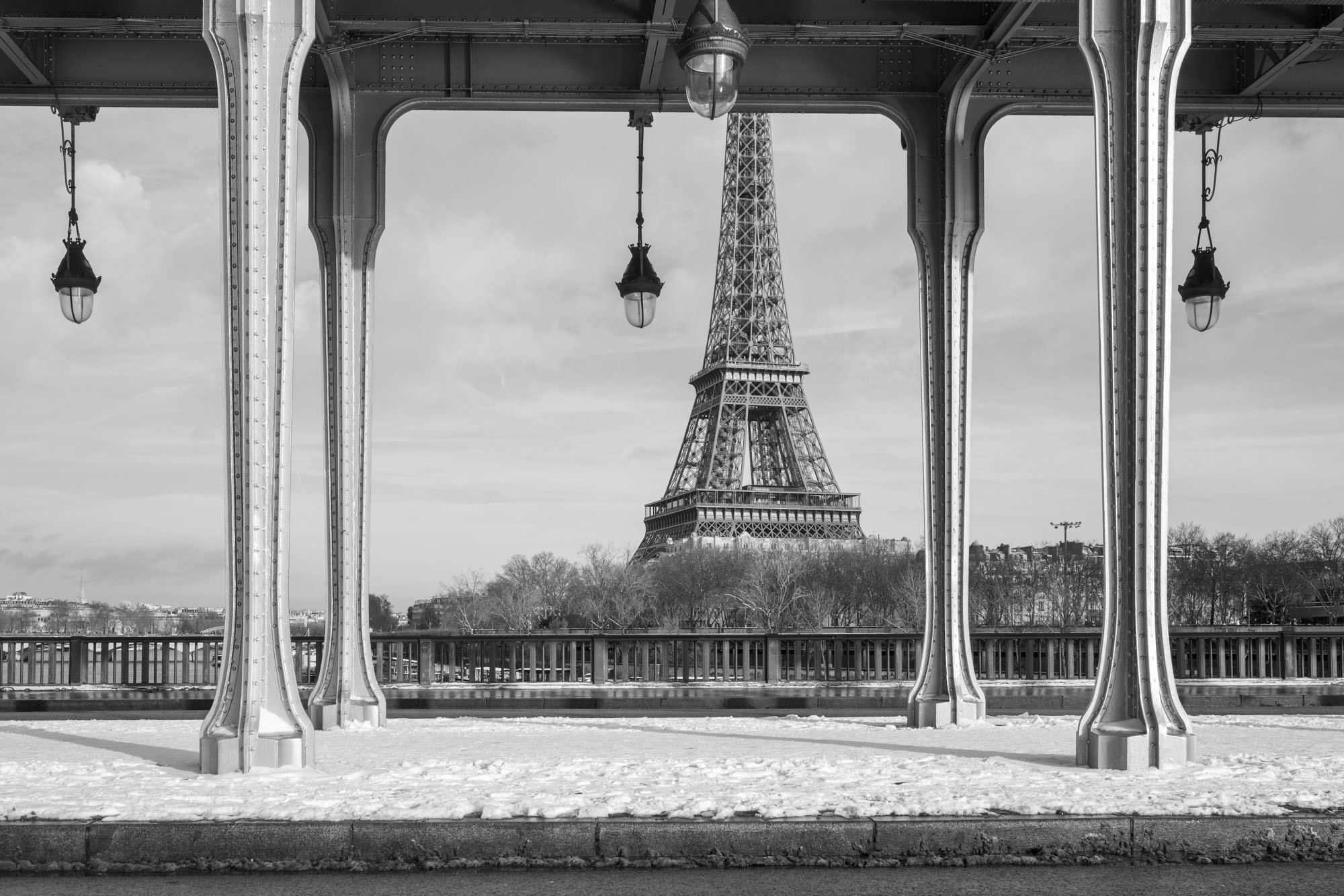  Empty esplanade framed by iron columns and lamps, the Eiffel Tower at its centre, Pont de Bir-Hakeim, Paris. Architecture photograph by Chris Perona. 