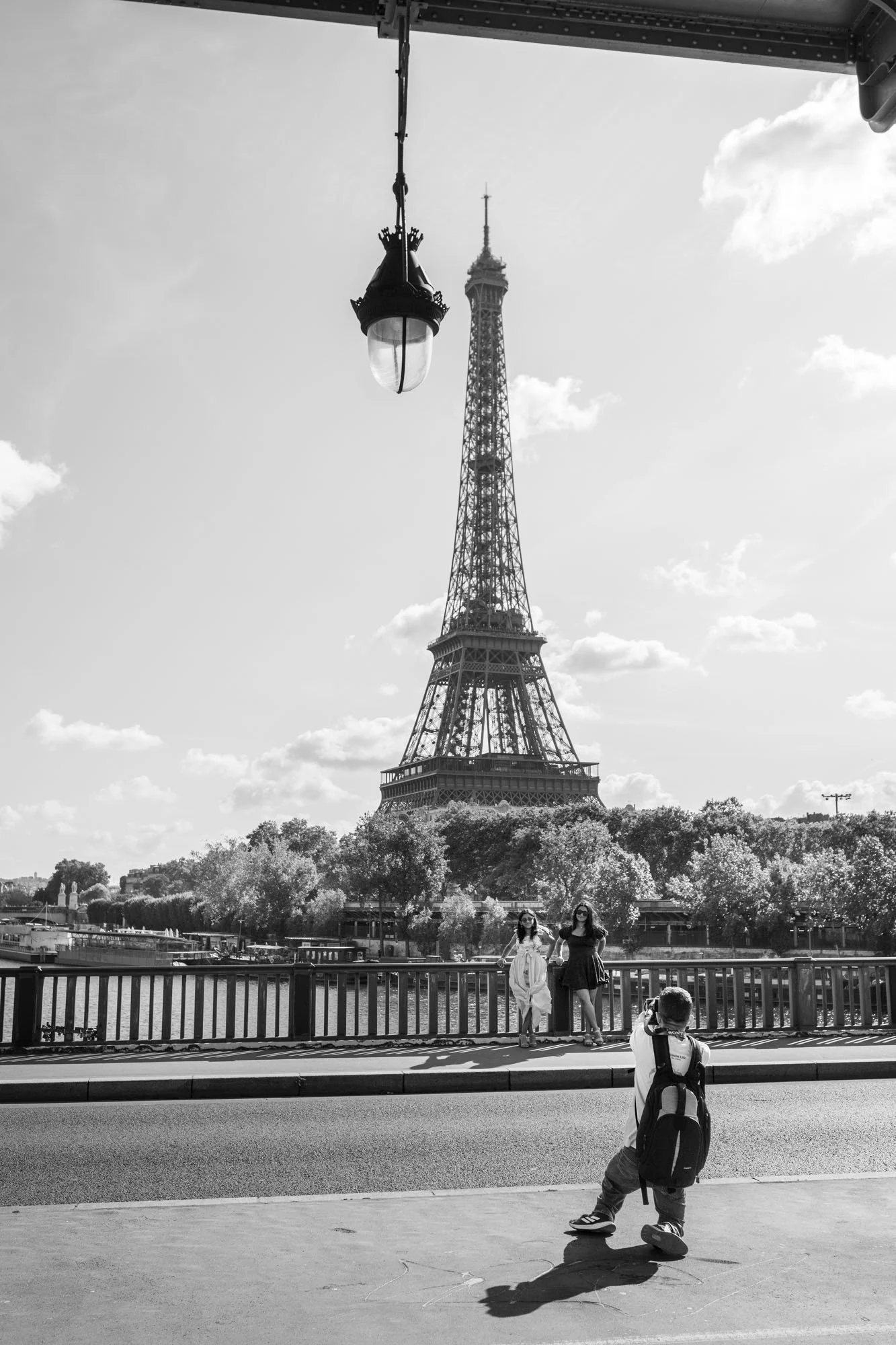  Skateboarder rolling across the bridge, the Eiffel Tower behind, Pont de Bir-Hakeim, Paris. Street photograph by Chris Perona. 