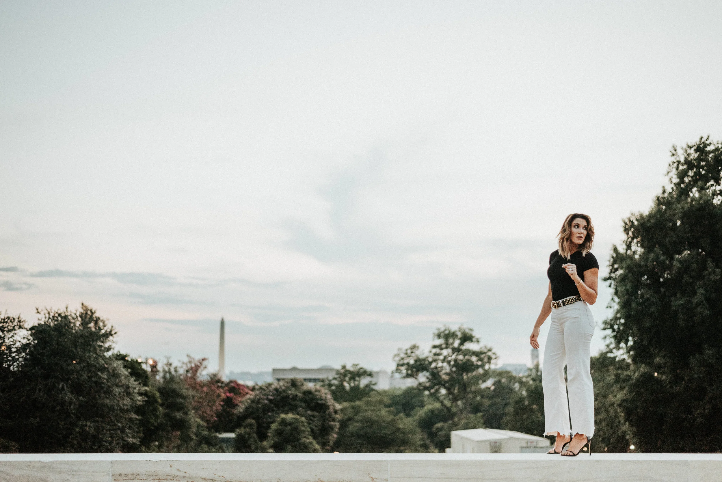 woman standing on ledge with Washington Monument in the distance