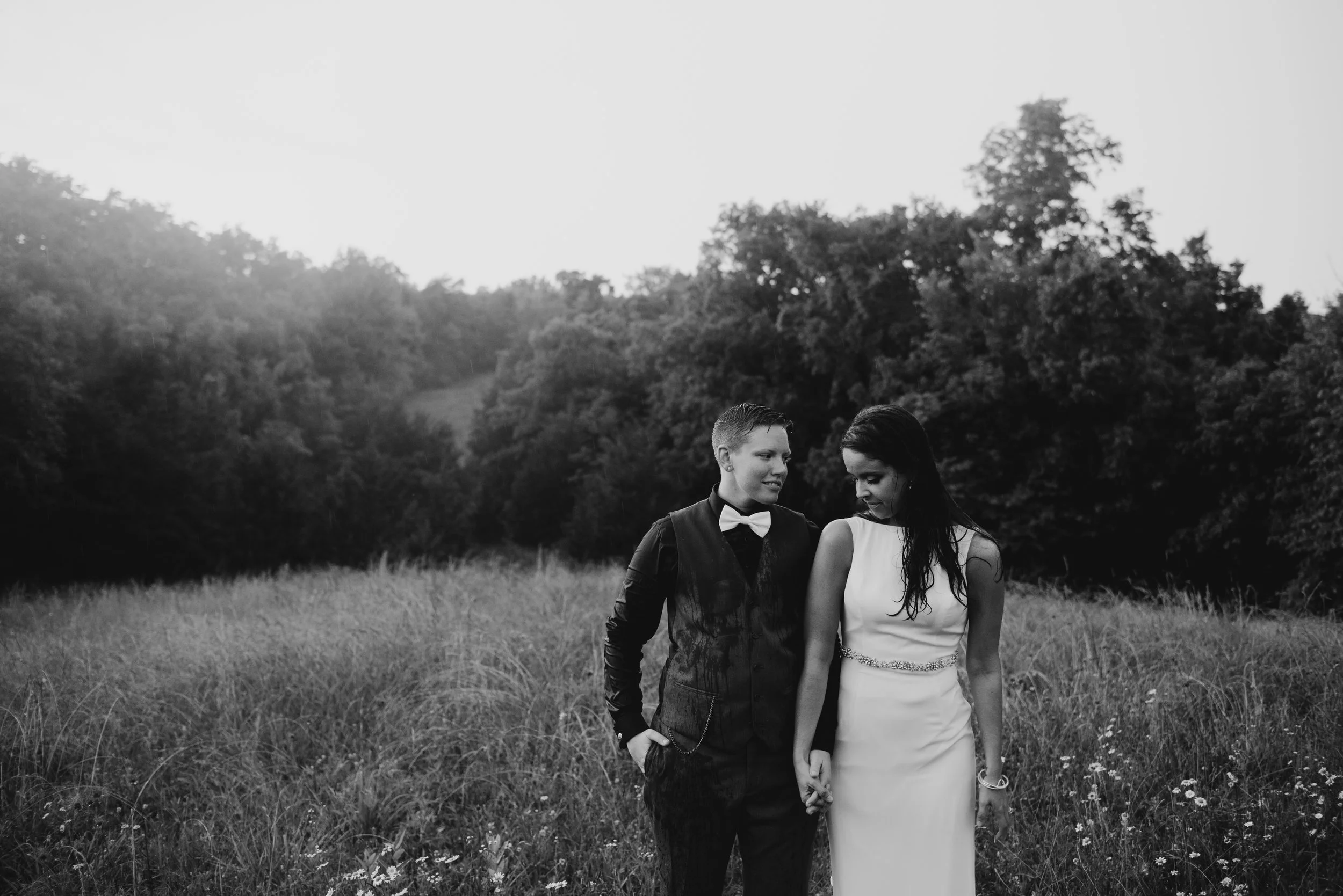 black and white photo of married women holding hands in Kentucky field